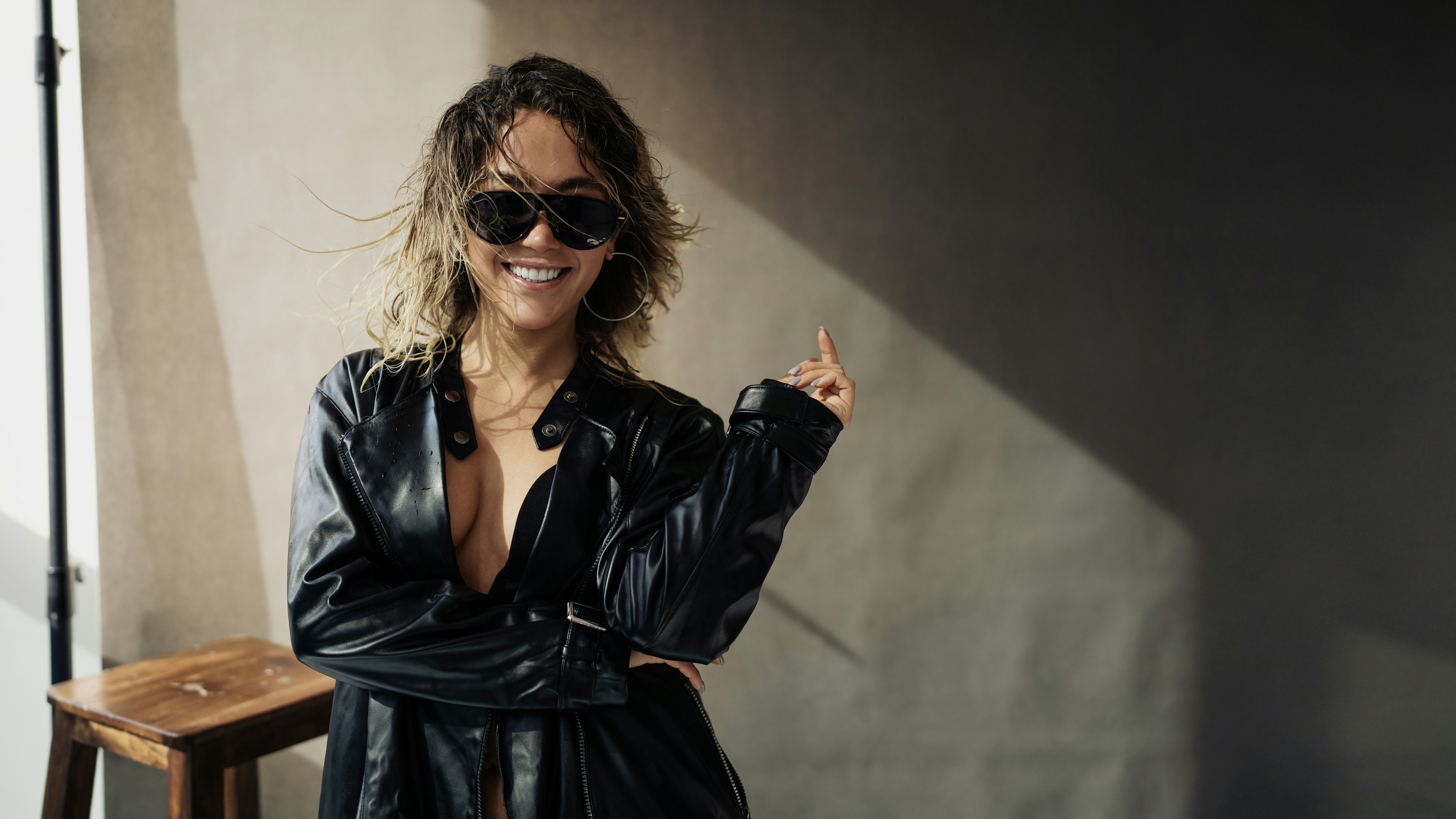 Woman in sunglasses and leather jacket smiles