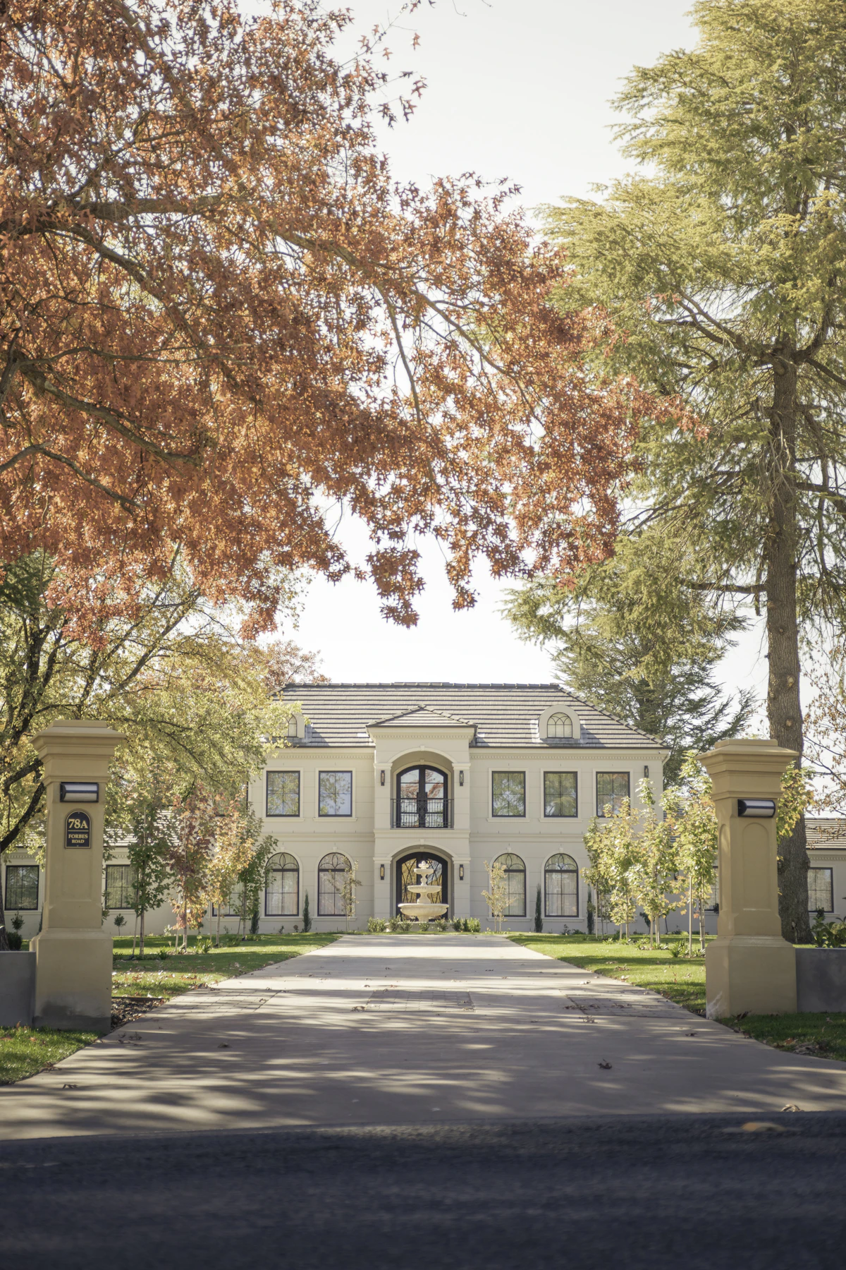 Gated estate with fountain courtyard in warm golden light at 7 Player Manor Court
