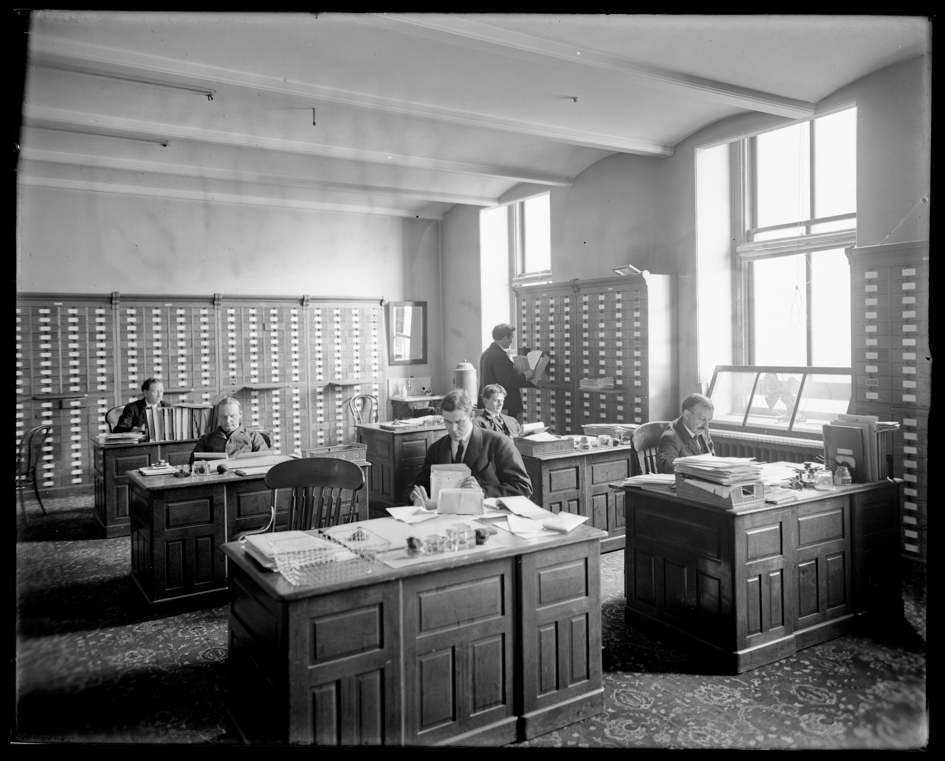 Men working in a vintage office with card catalogs