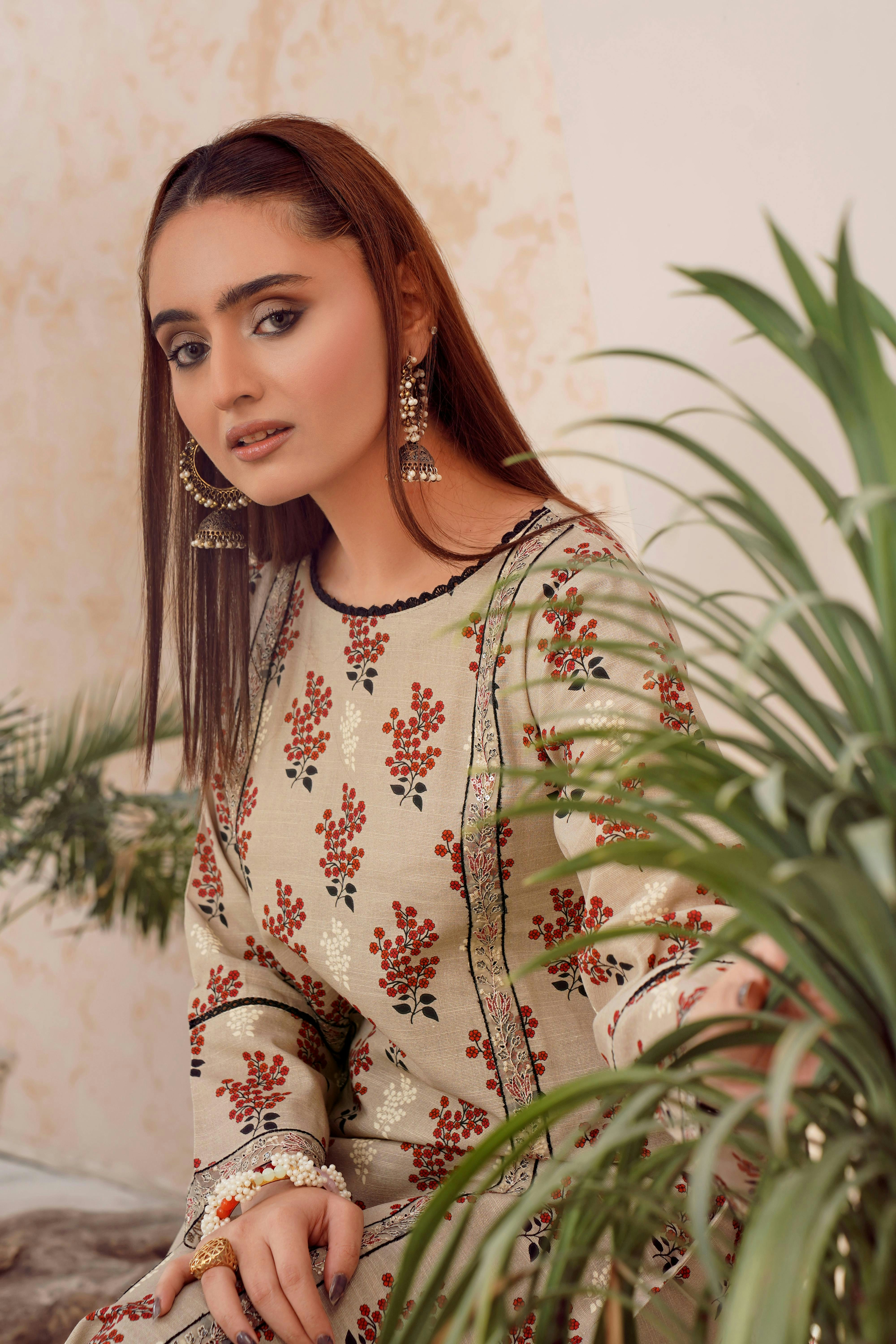 Wanita muda dengan pakaian bermotif dan anting-anting besar.