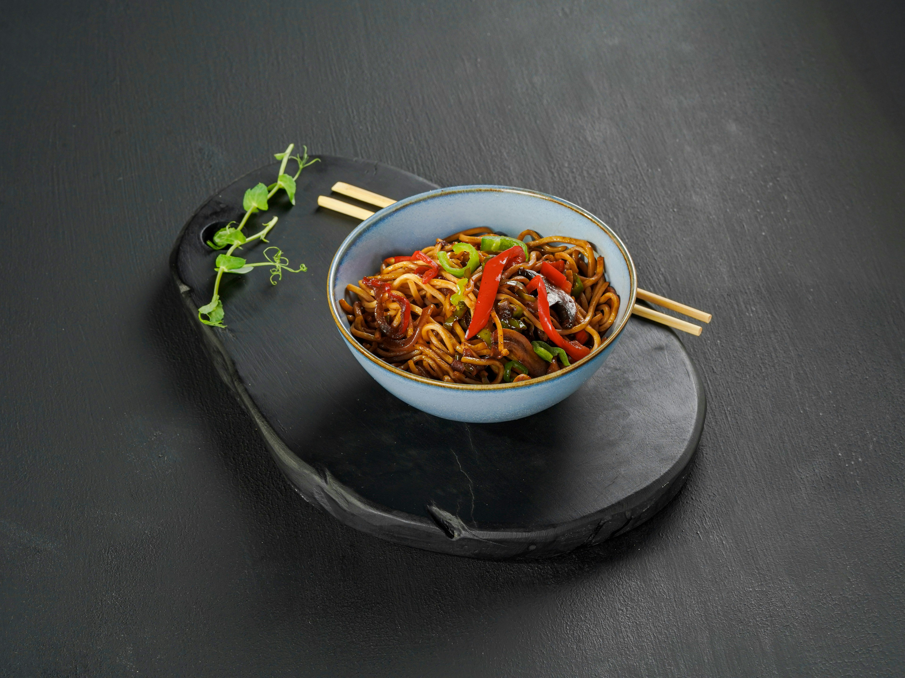 Bowl of stir-fried noodles with chopsticks
