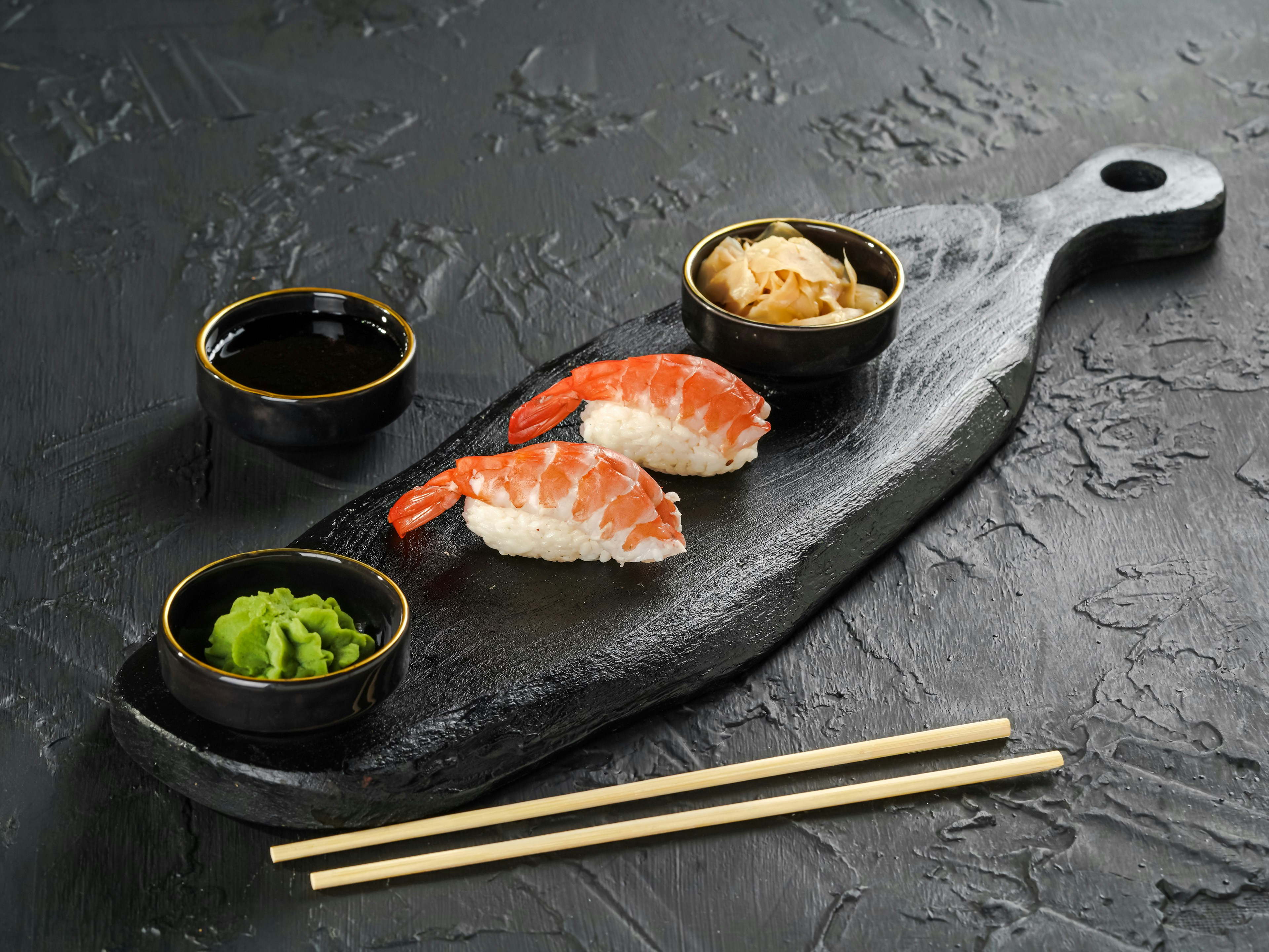 Shrimp nigiri on a dark board