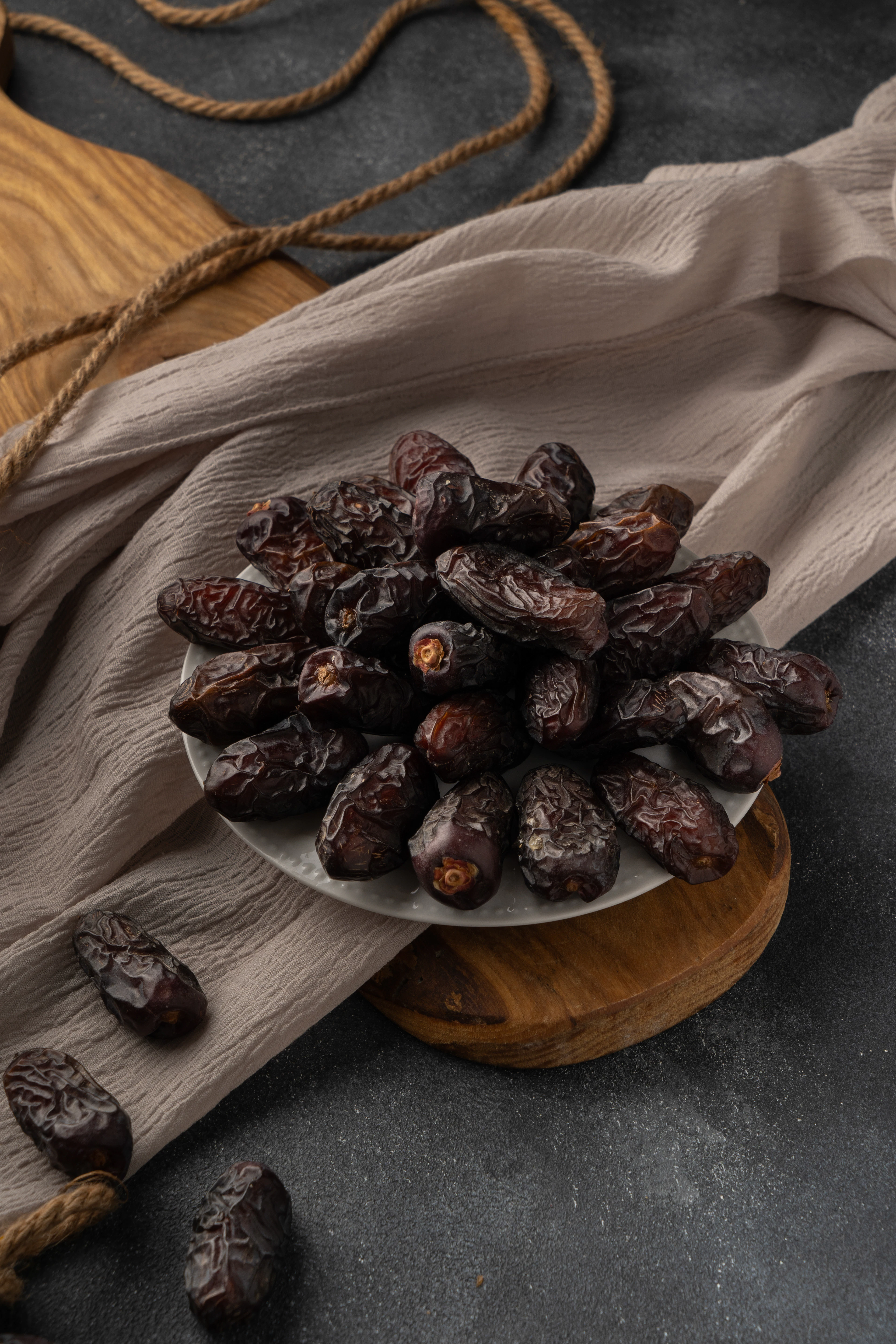 Kurma tersaji di atas piring dengan kain linen