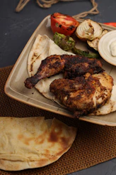 Grilled chicken with vegetables and flatbread on a plate