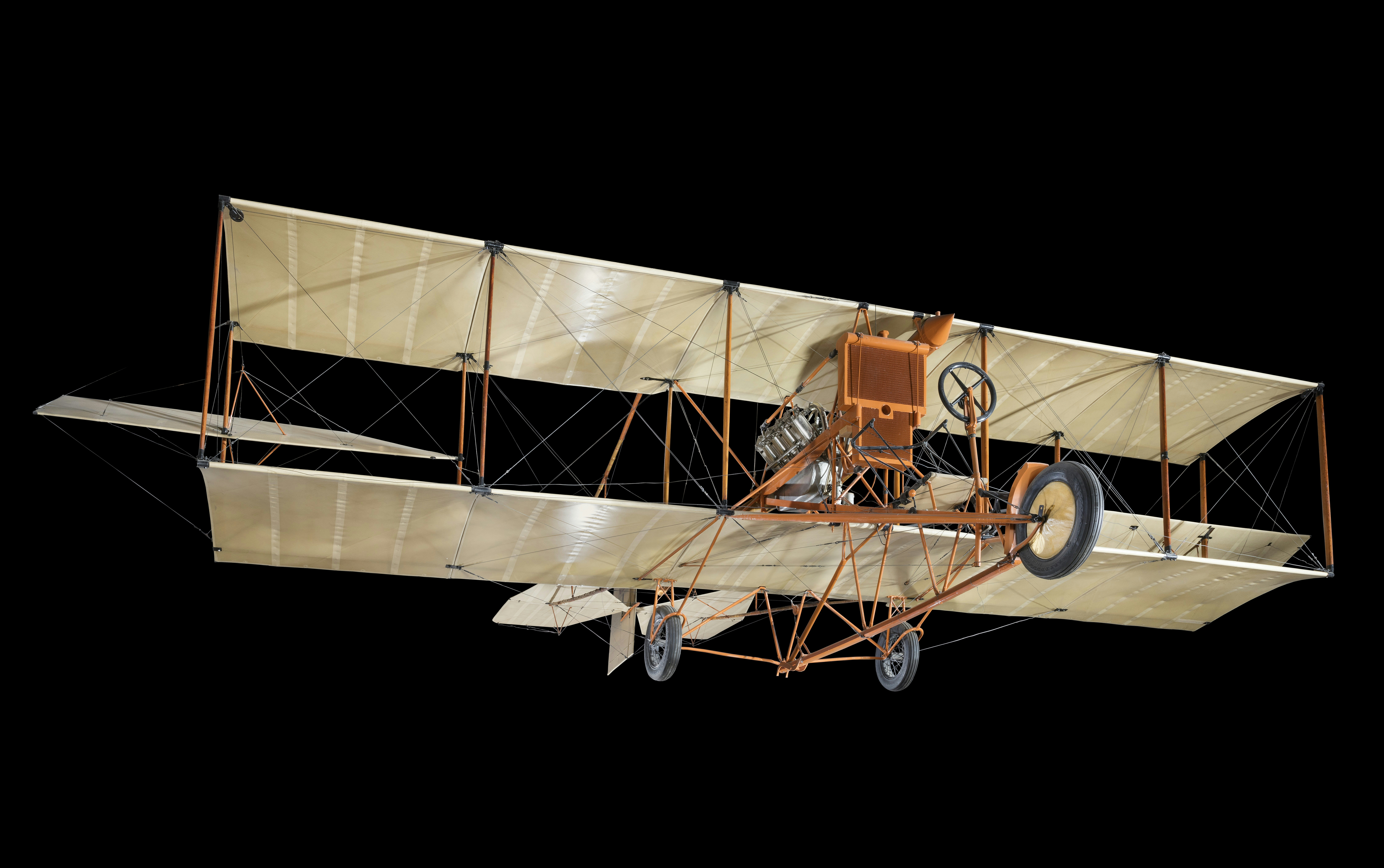 Un biplan vintage avec un cockpit ouvert sur fond noir