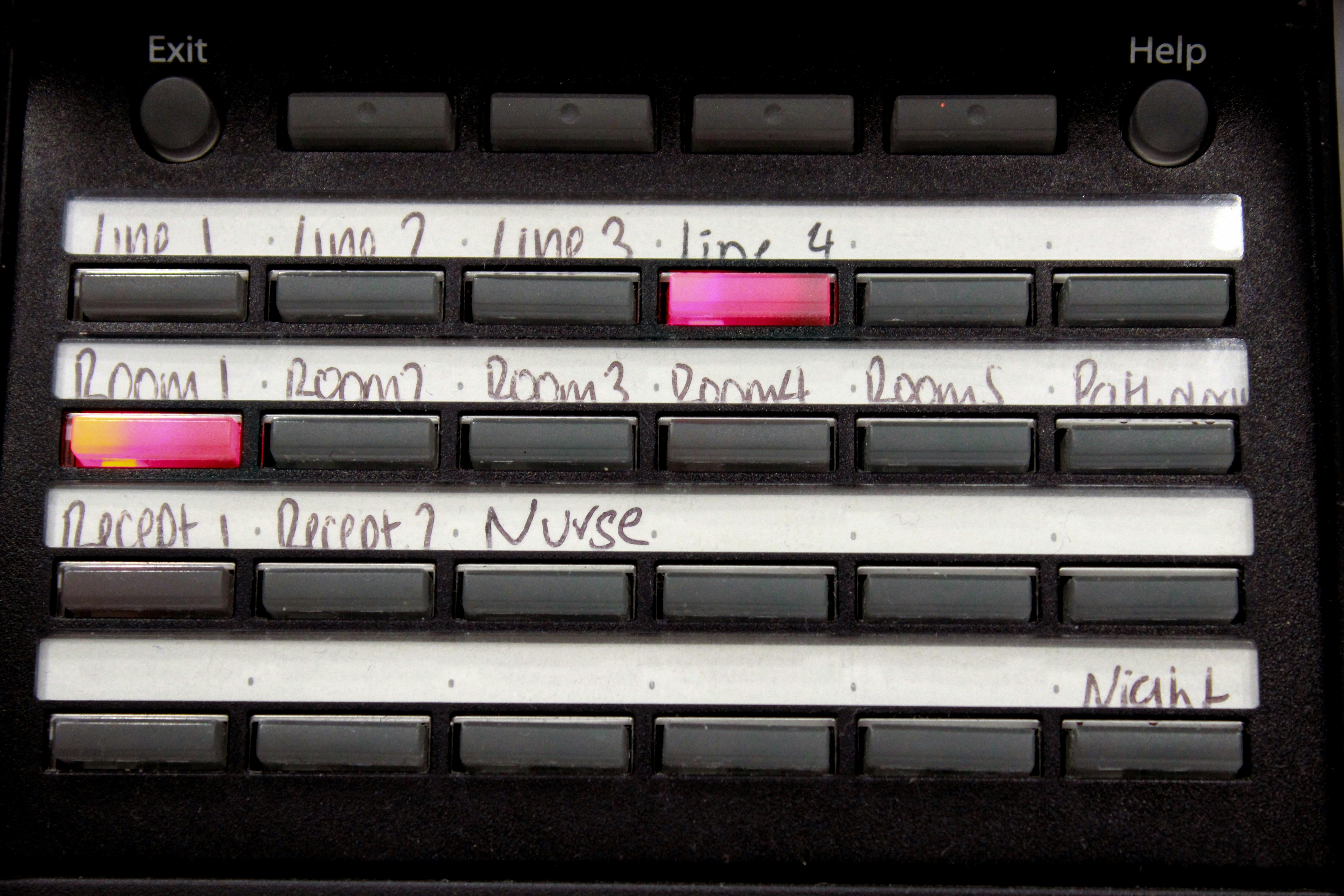 Buttons labeled with handwritten text on a control panel.