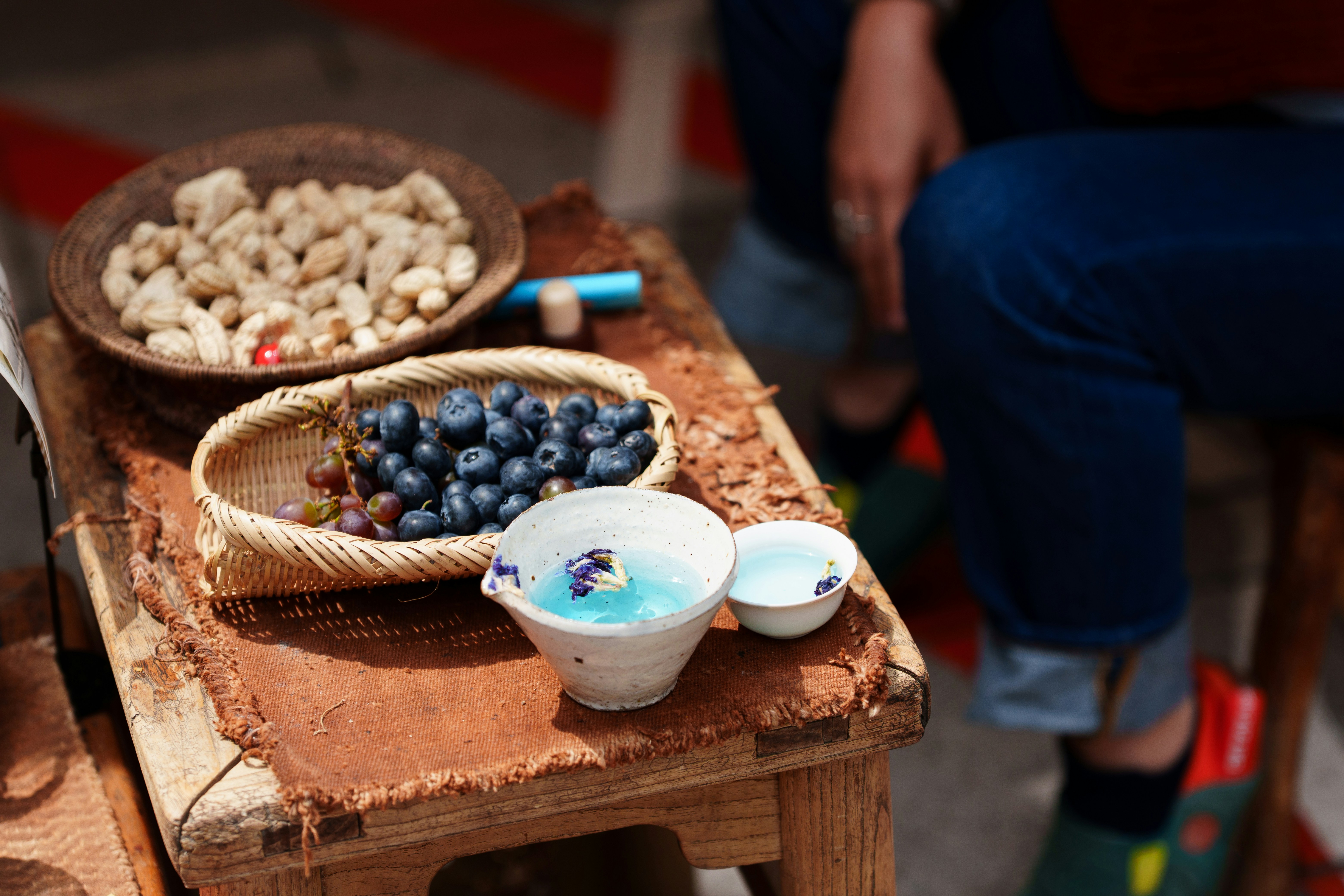 Blueberries, nuts, and drinks on a wooden stool.