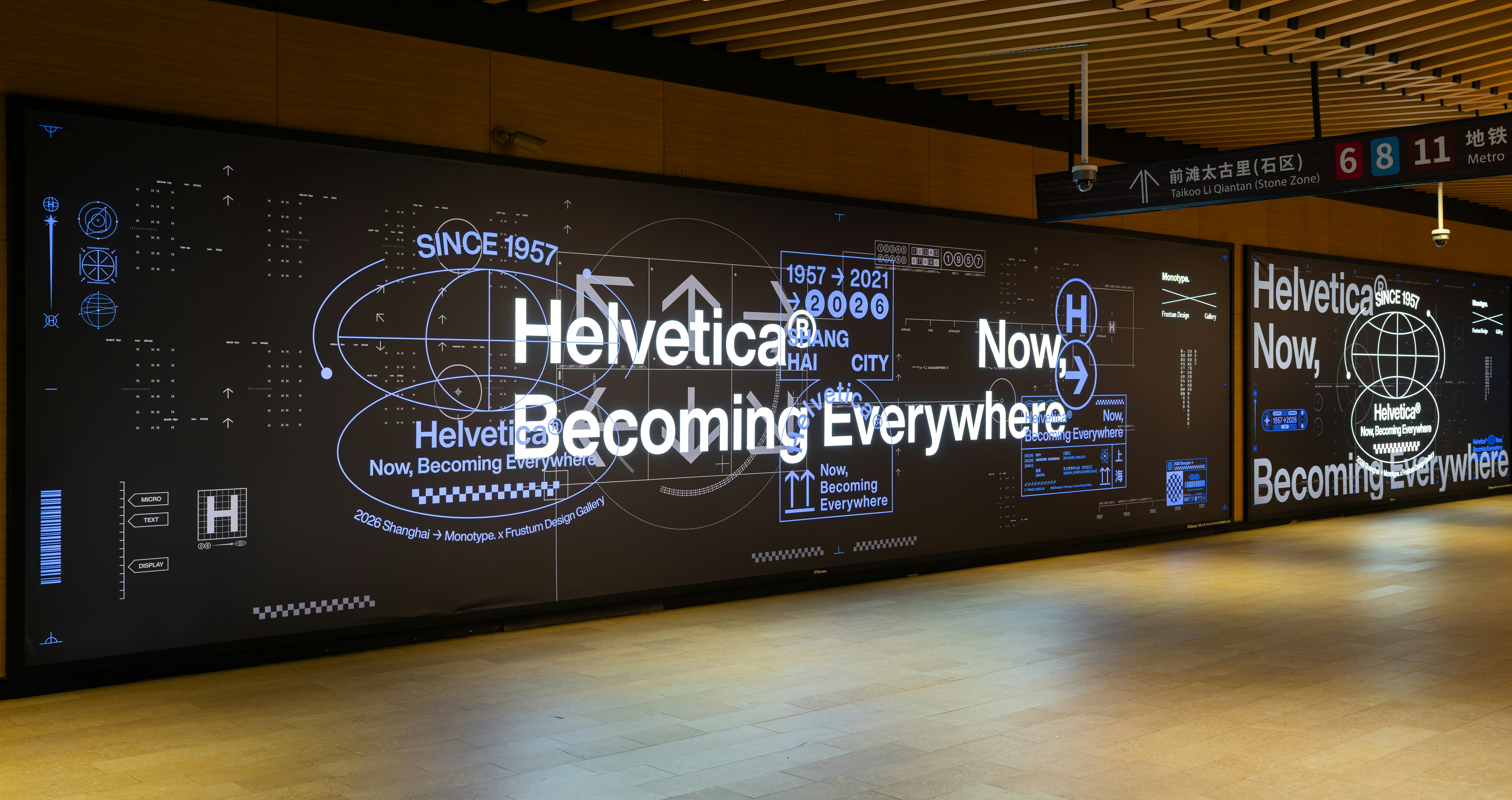 Large digital display with "helvetica now becoming everywhere" text.