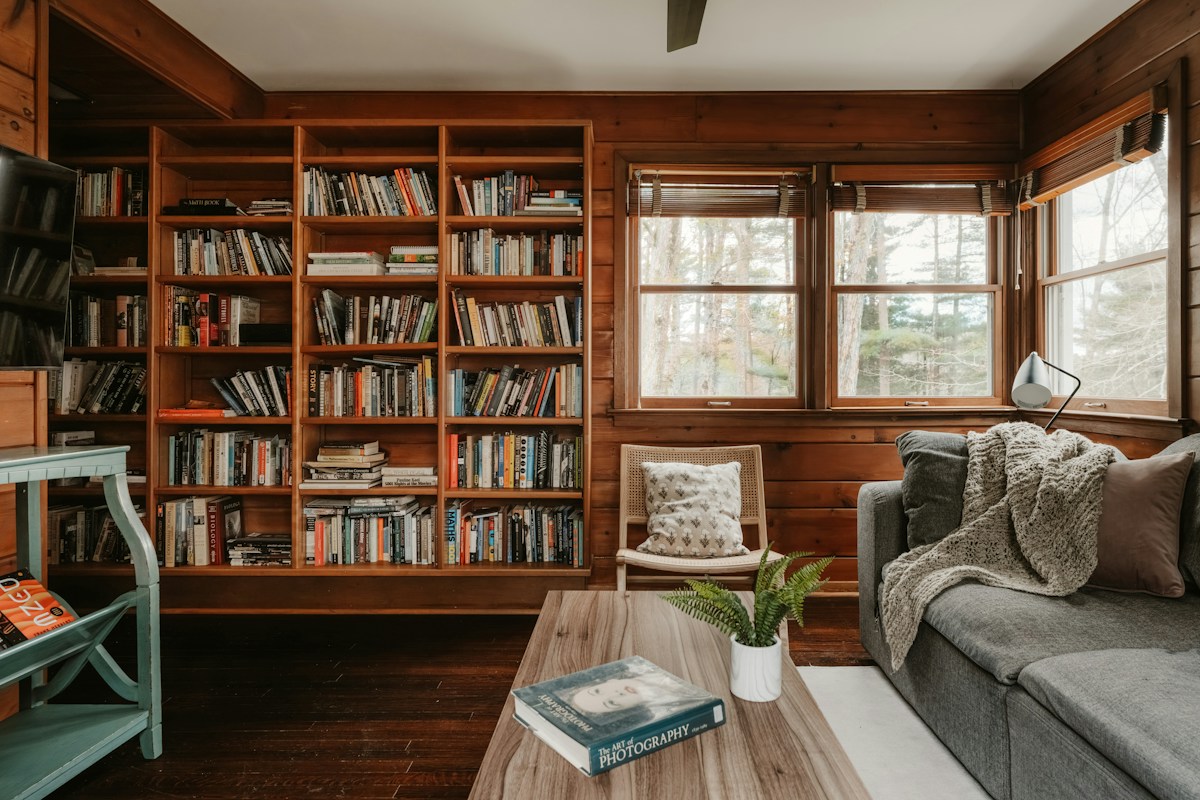Cozy living room with a large bookshelf filled with books and comfortable seating, ideal for homeschool organization ideas.