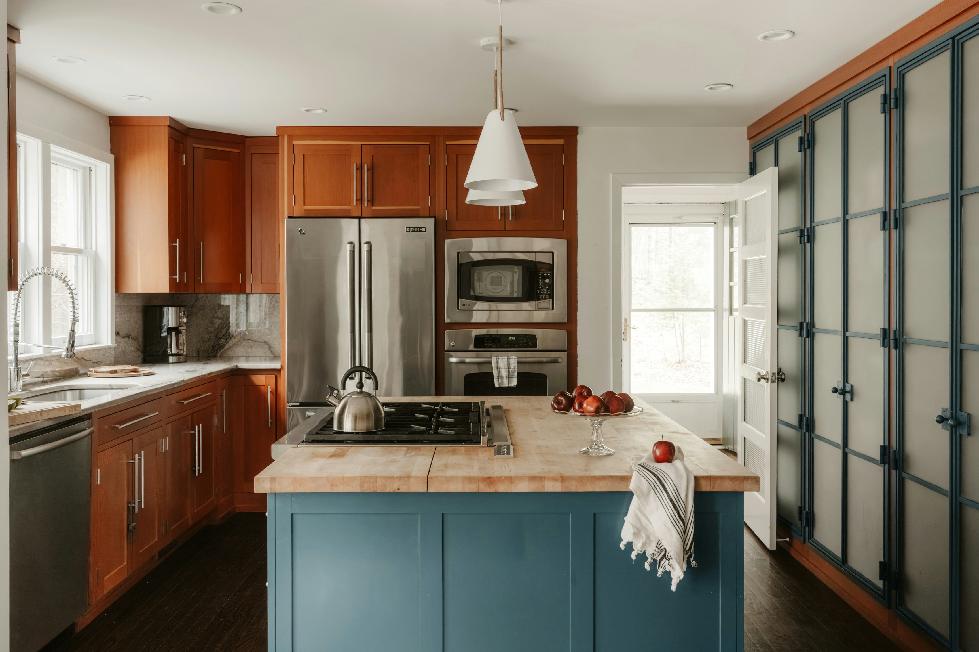 Modern kitchen with blue island and wood cabinets