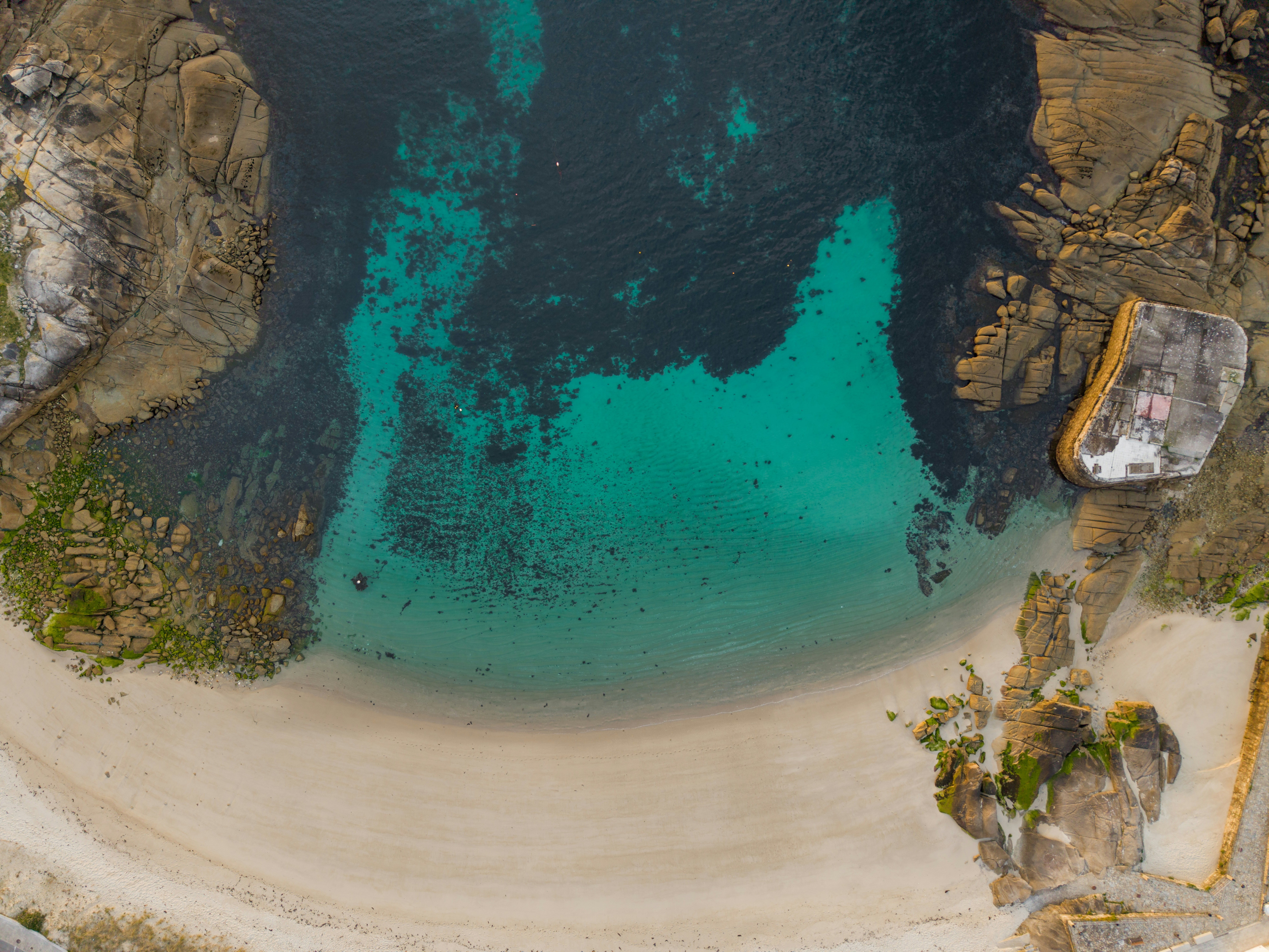 Vista aérea de una playa apartada con aguas turquesa claras.