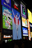 Bright neon signs illuminate a city street at night.