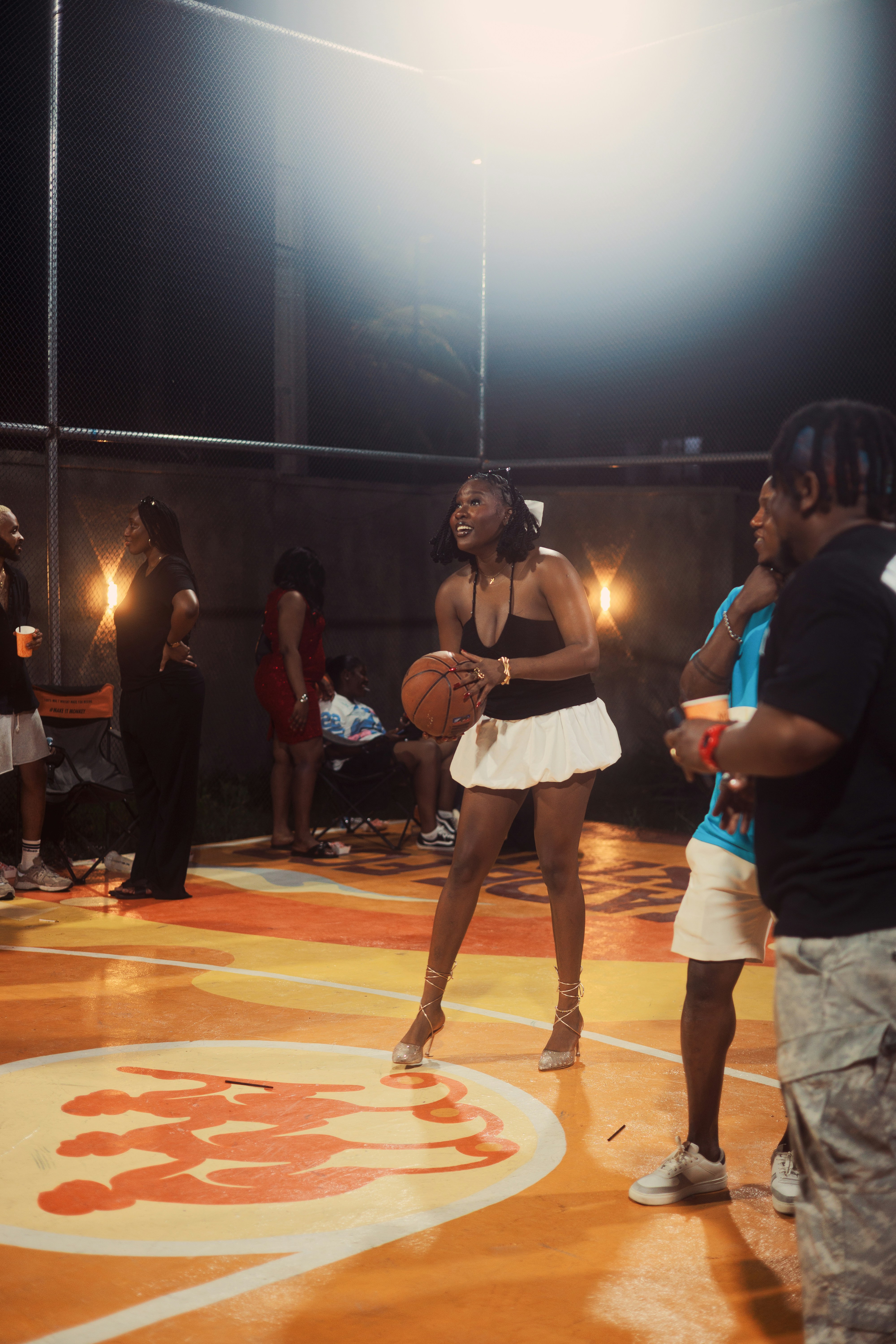 Woman holding basketball on illuminated court