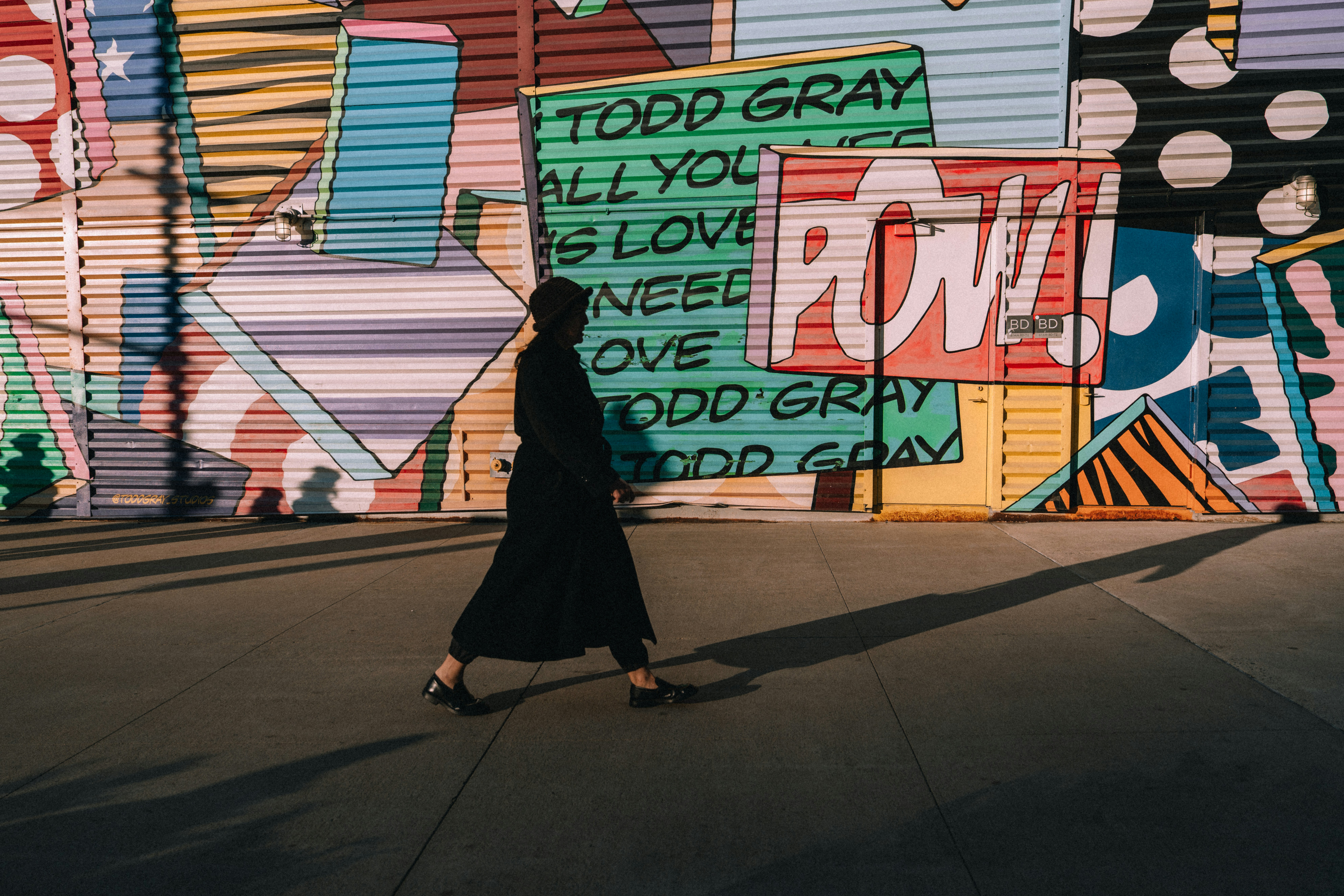 Person walks past colorful graffiti art wall