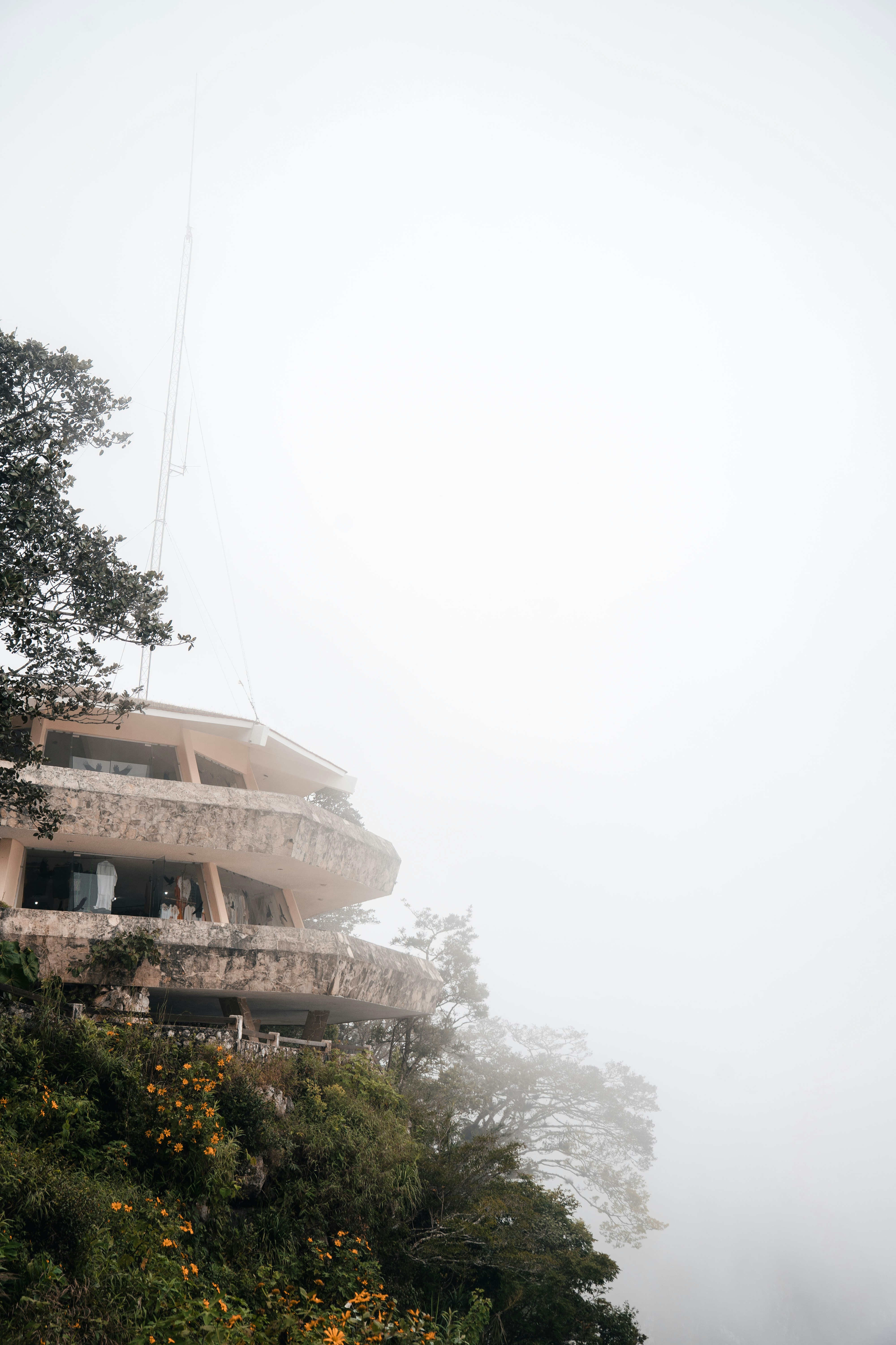Edificio sul bordo di una scogliera circondato dalla nebbia