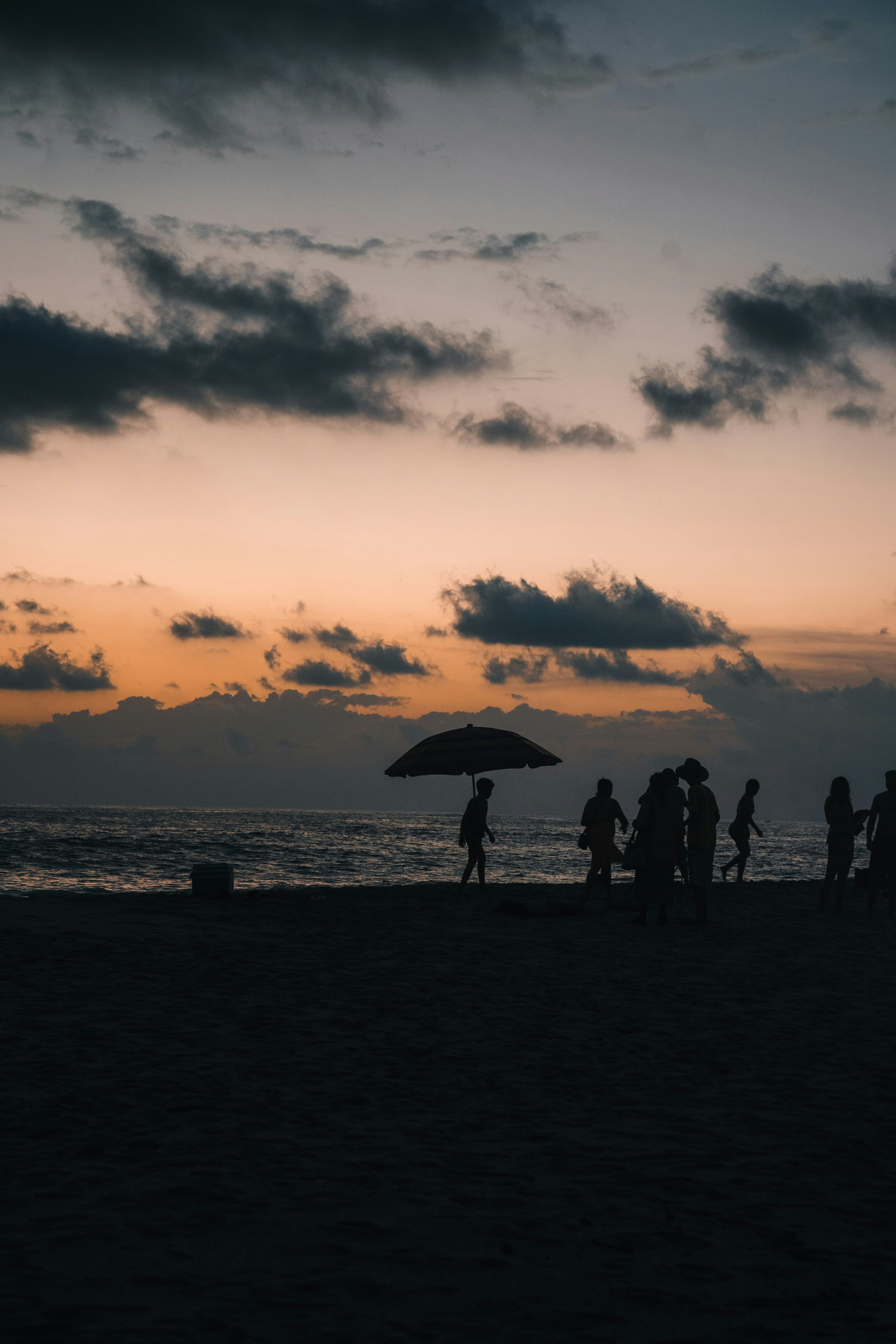 Silhouette di persone su una spiaggia al tramonto