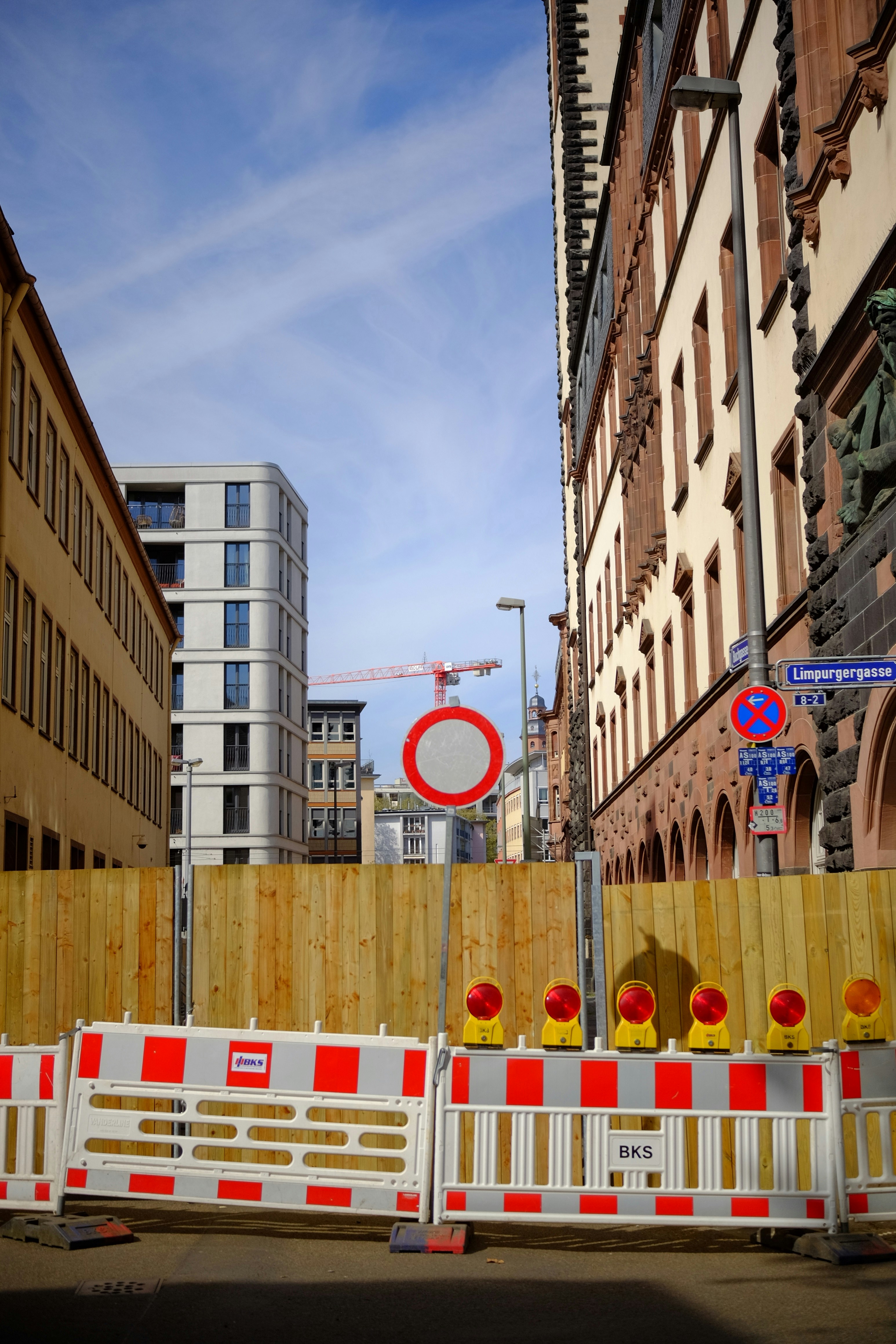 Baustelle mit Barrieren und Gebäuden unter blauem Himmel