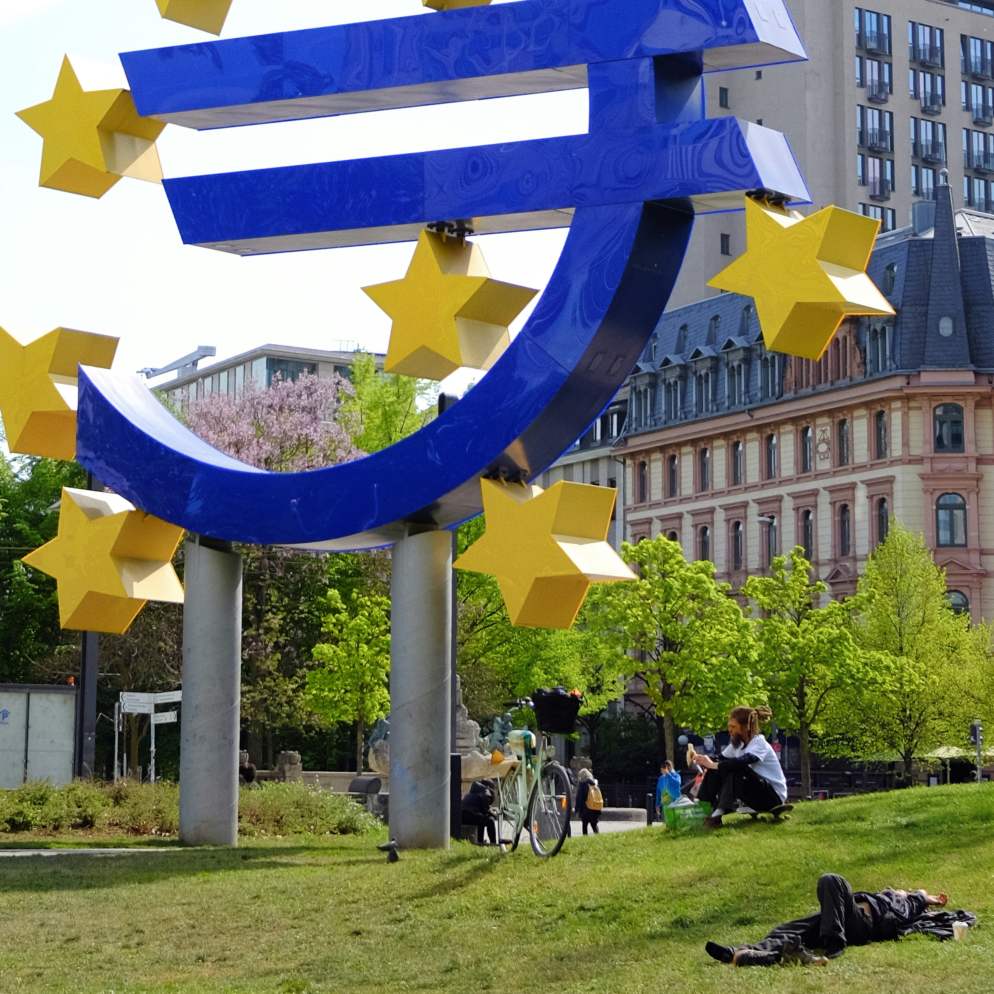 Riesige blaue Euro-Symbol-Skulptur mit gelben Sternen.
