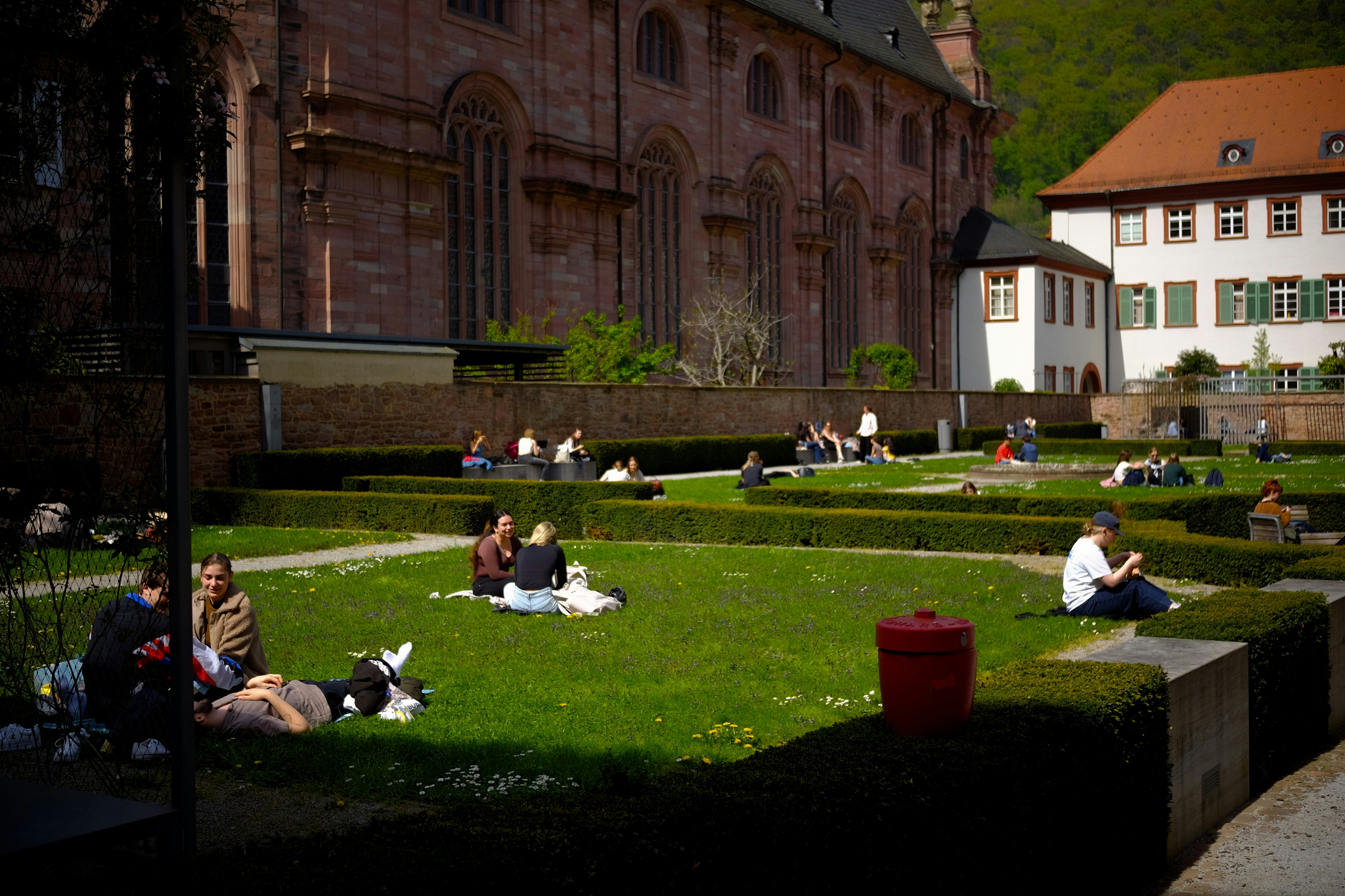 Menschen, die sich in einem gepflegten Garten mit nahegelegenen Gebäuden entspannen