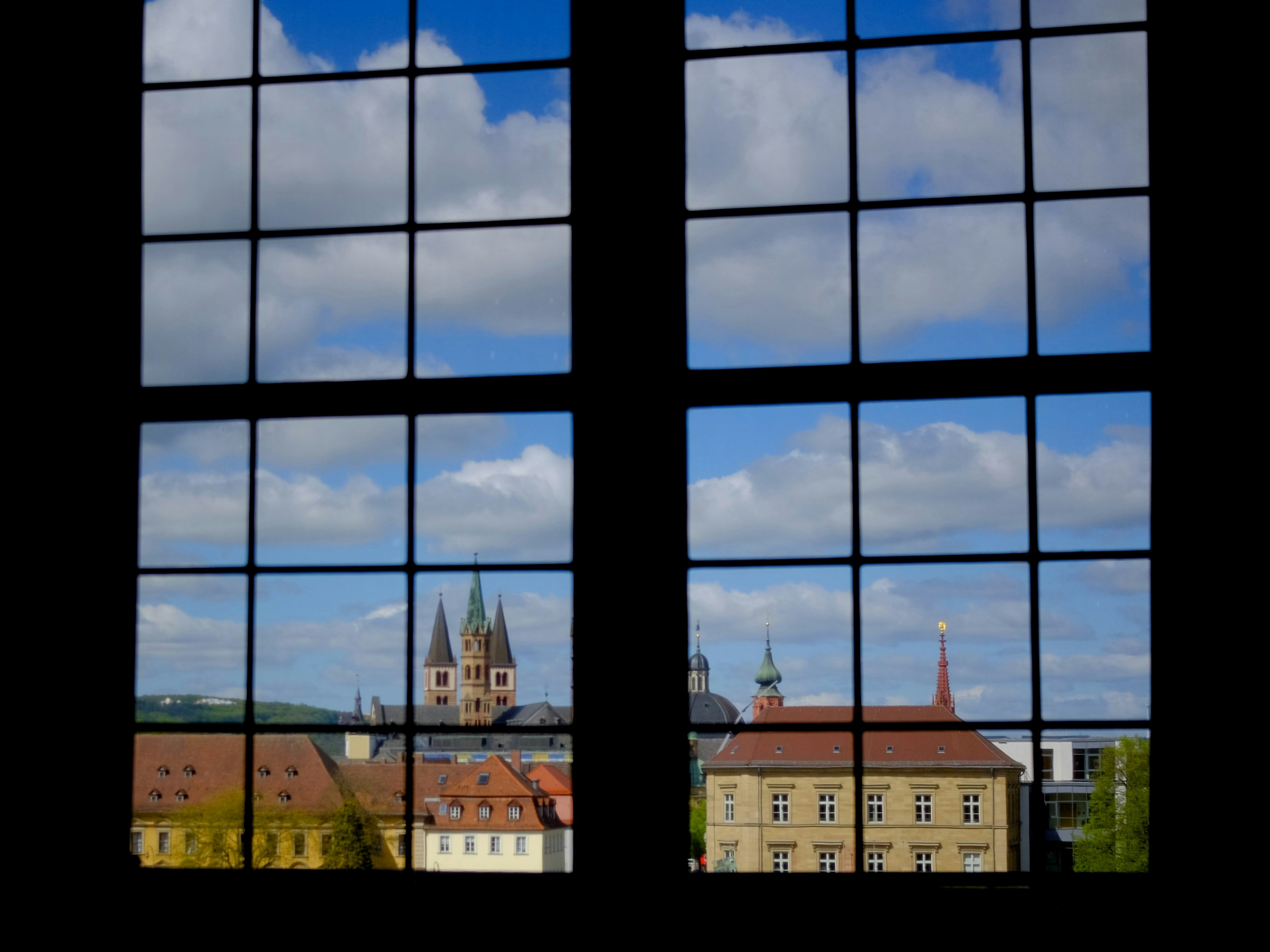 Blick auf Stadtgebäude und Himmel durch das Fenster