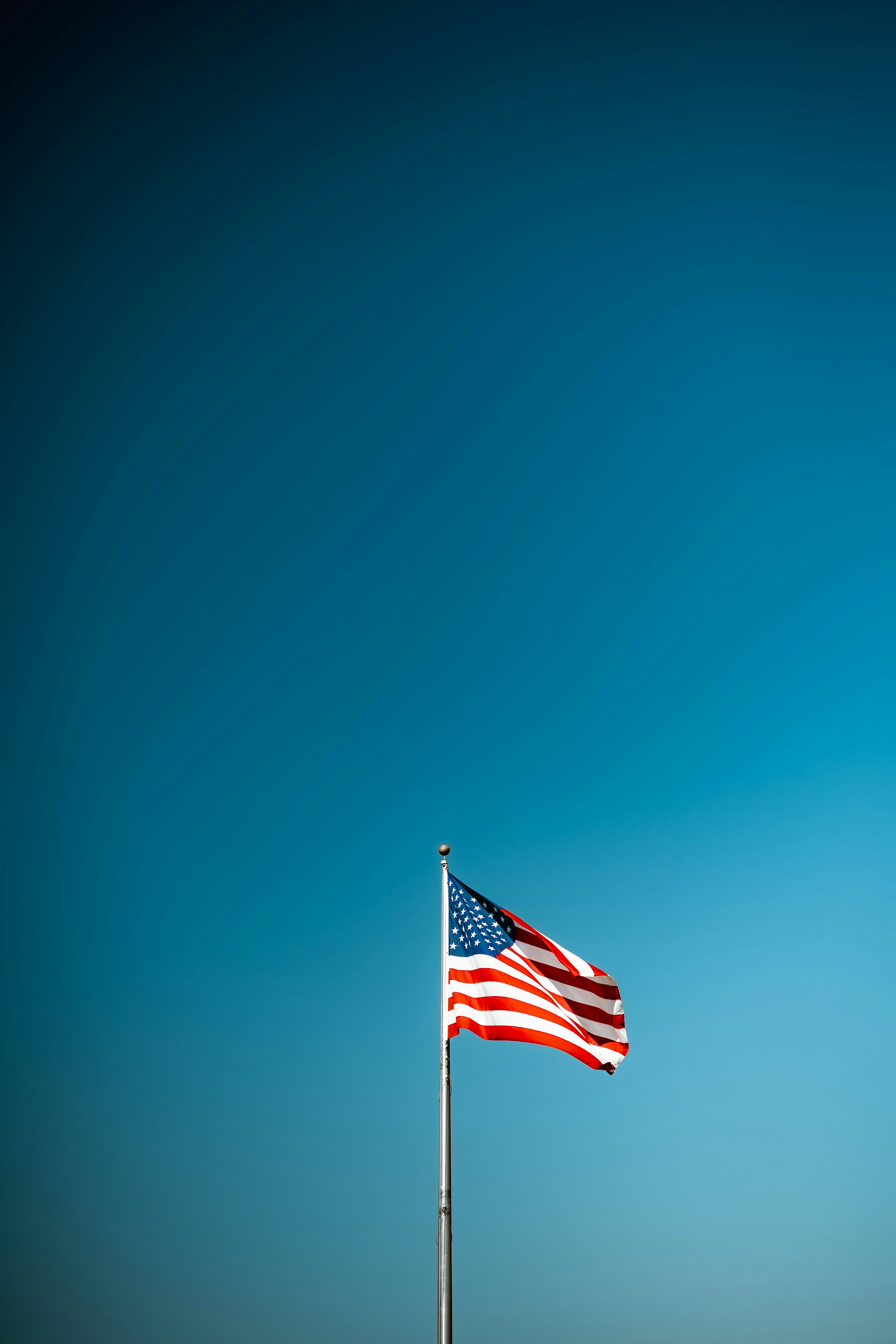 American flag waving against a clear blue sky