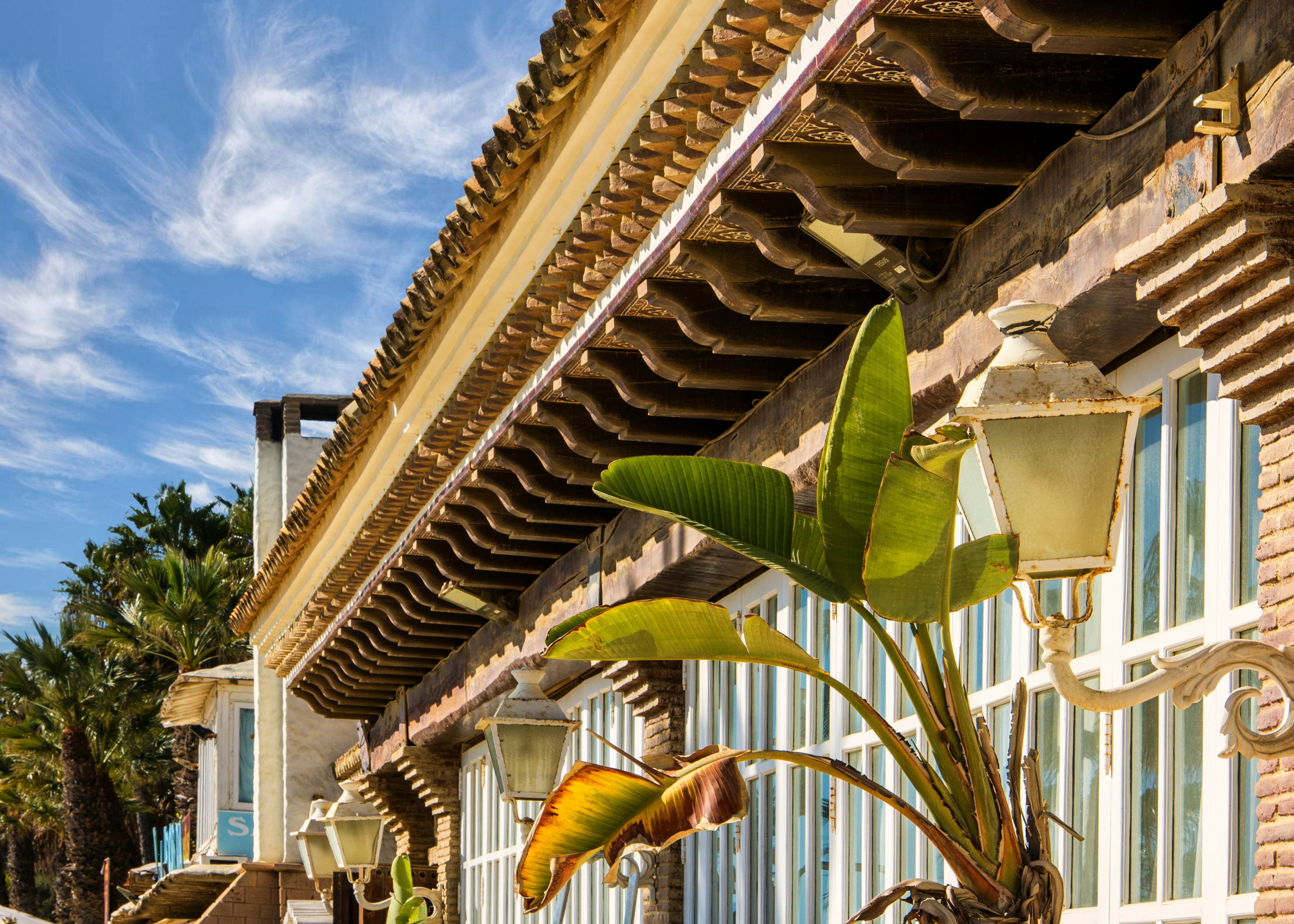 Building with ornate roof and tropical plants