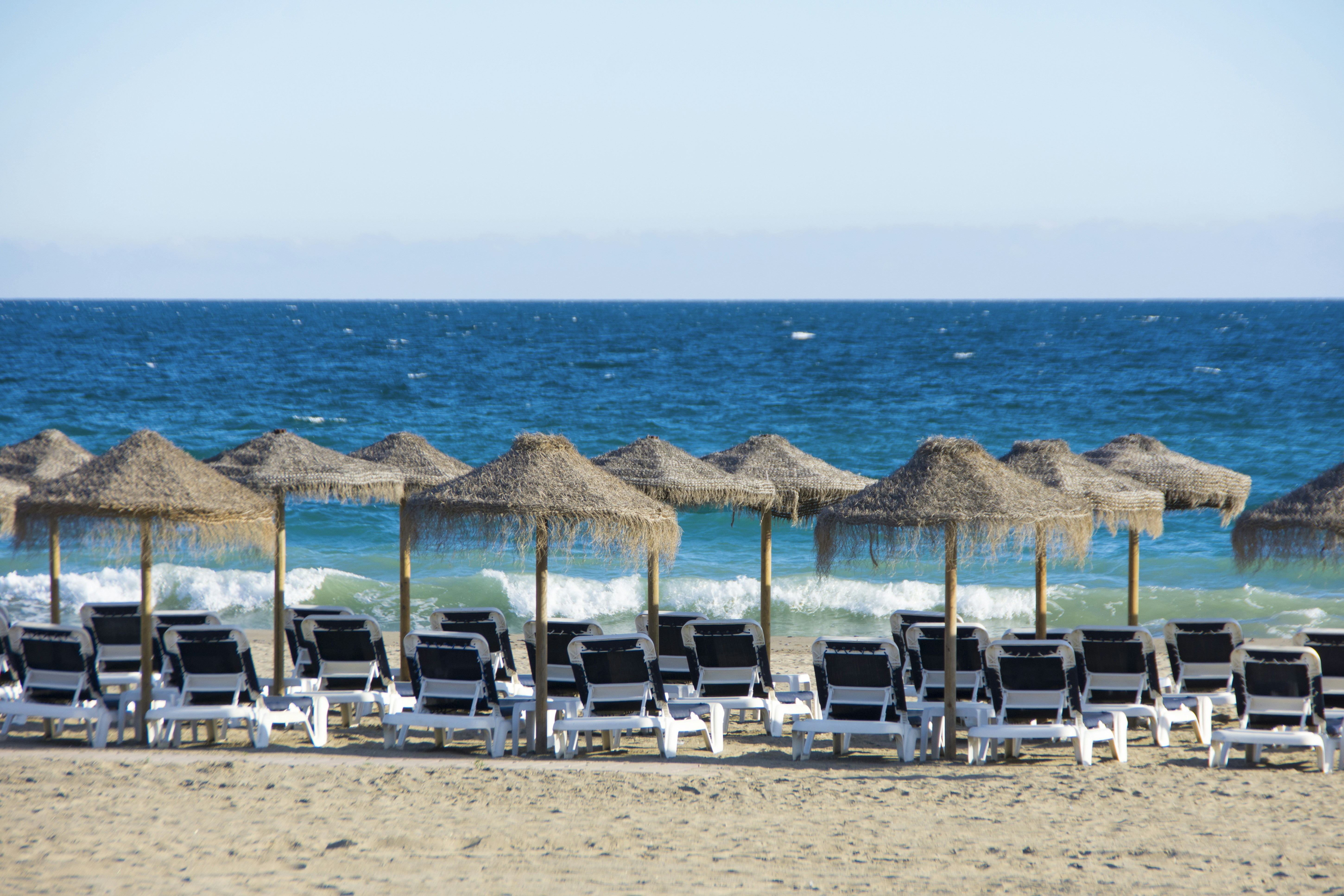Zona de hamacas con módulos ordenados y sombrillas en playa española