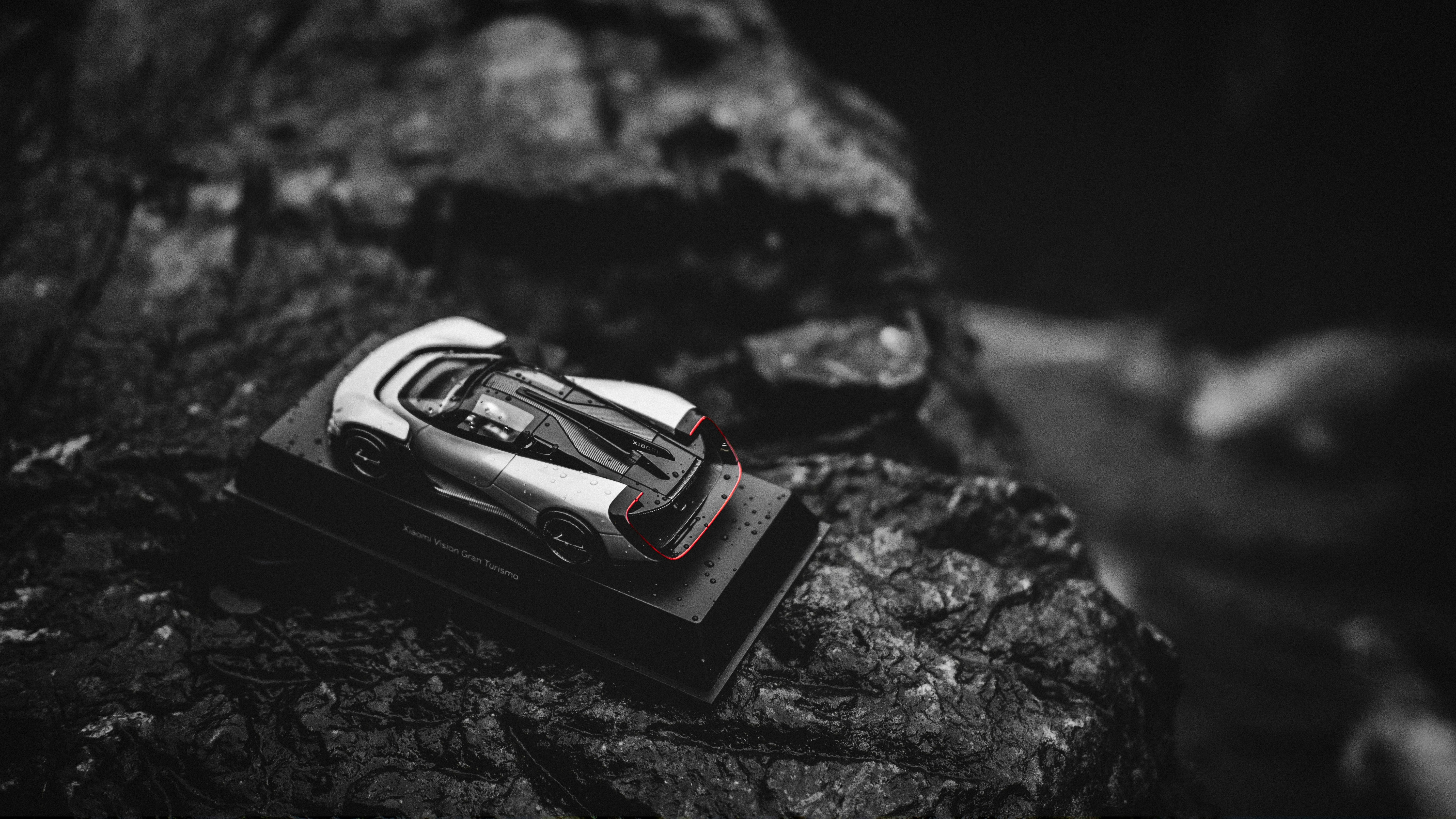 A sleek silver sports car model on a display stand.