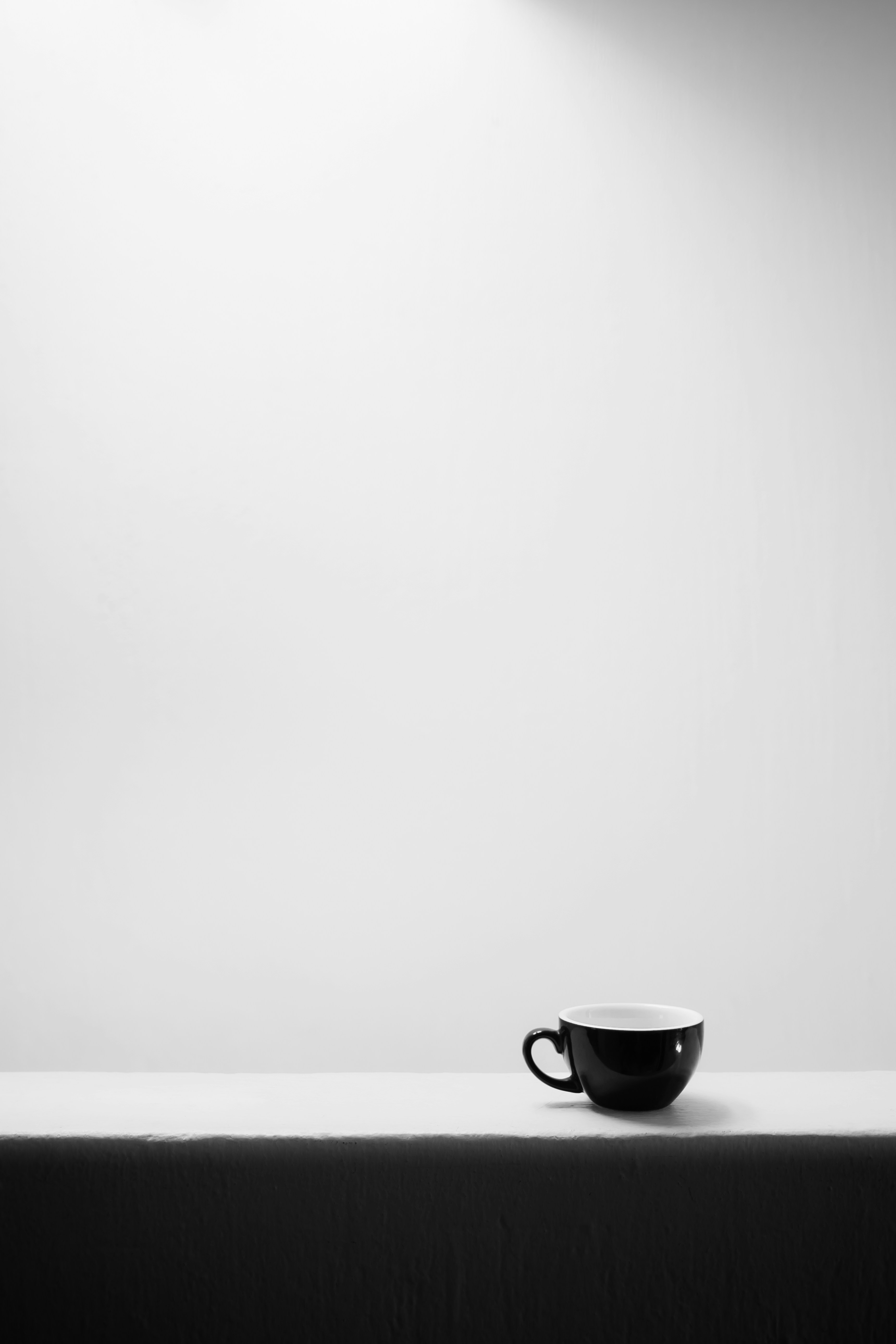 Una tazza di caffè nero solitaria su una superficie bianca