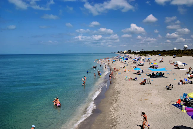 People enjoying a sunny day at a crowded beach.