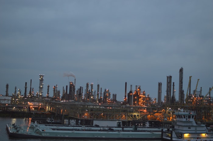 Oil refinery complex at dusk near waterway