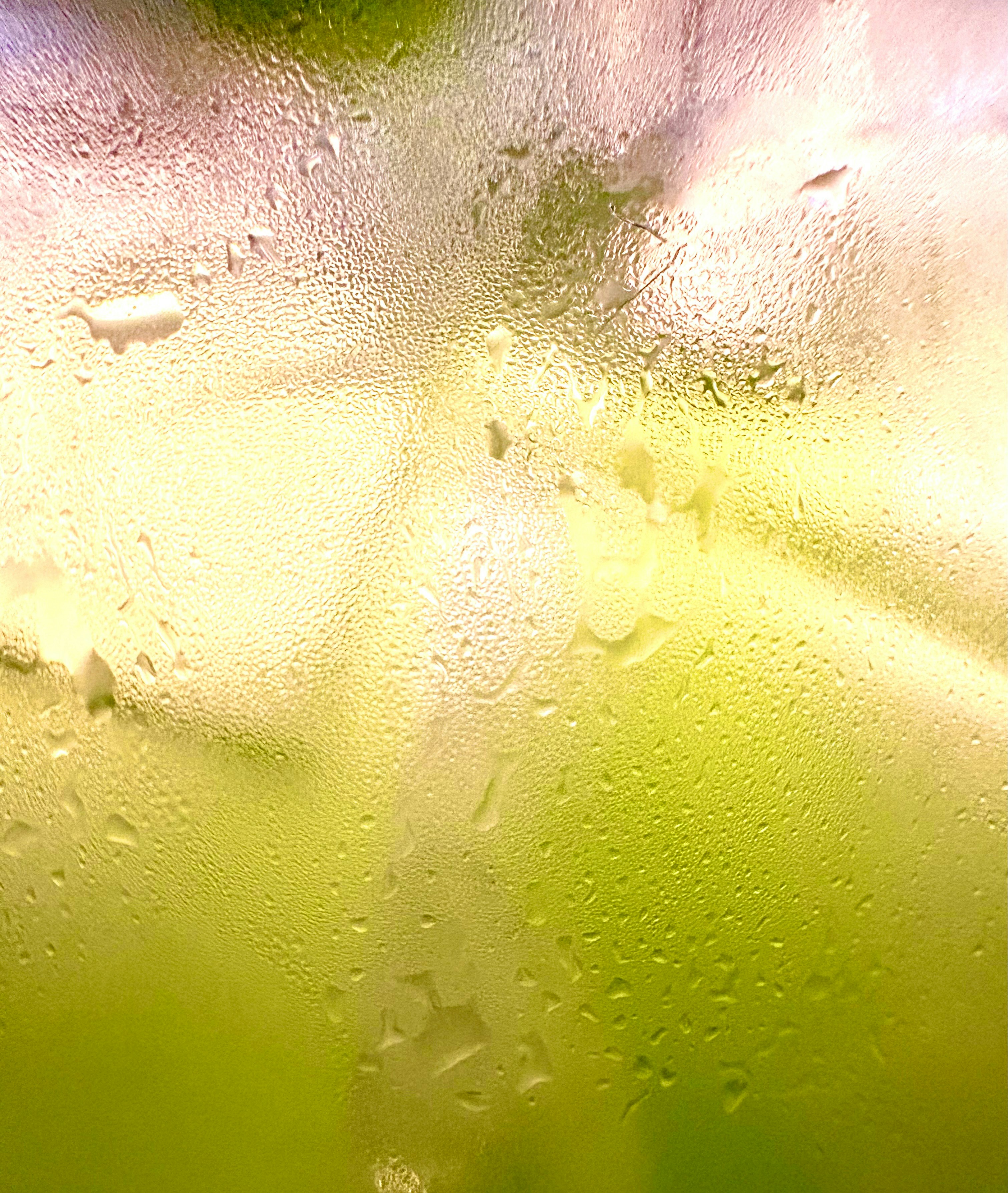 Plan rapproché de la condensation sur un verre avec une boisson jaune-vert.