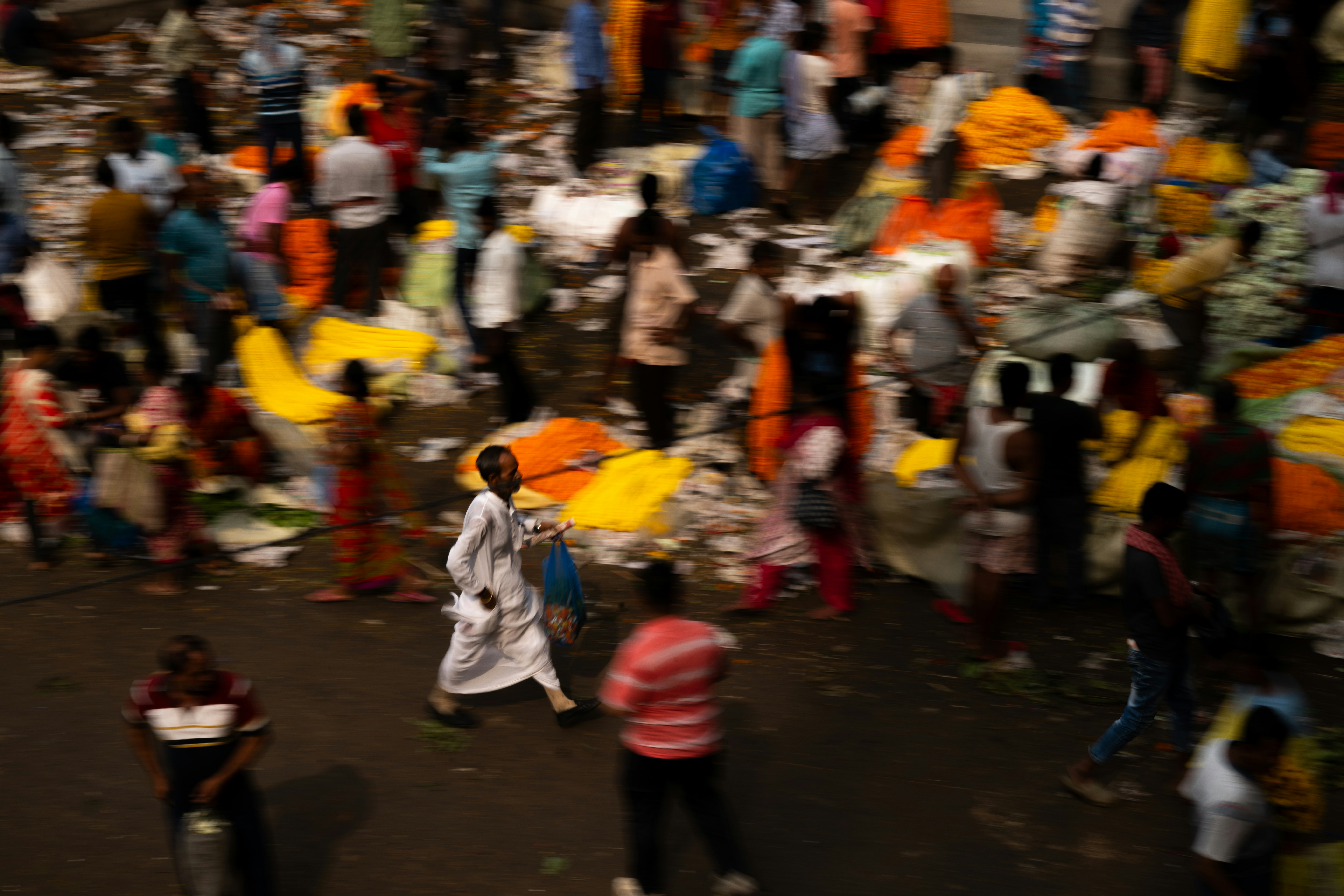 Crowded street scene with people and colorful items