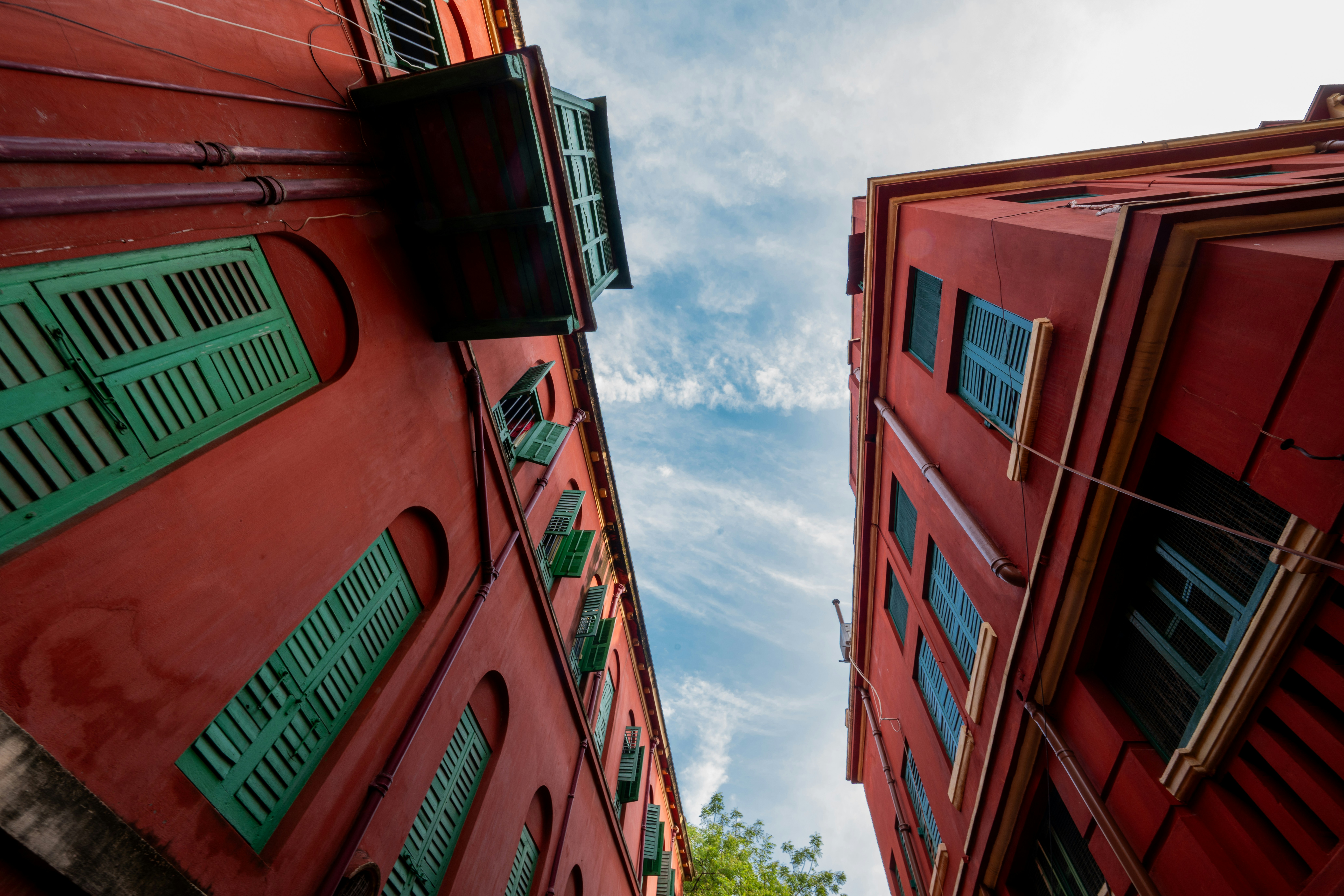 Zwei rote Gebäude mit grünen Fensterläden gegen den Himmel