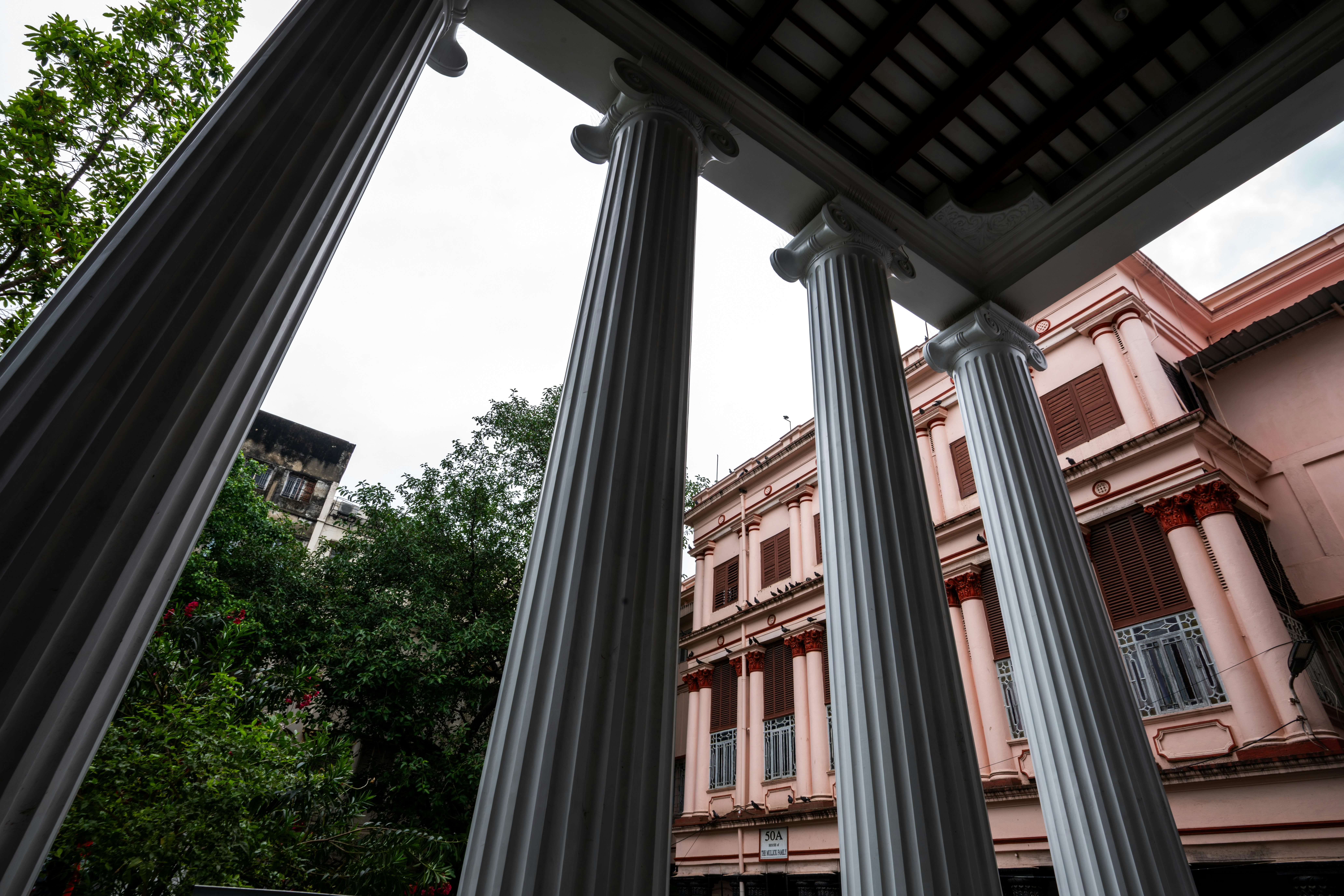 Classical columns frame a pink building facade.