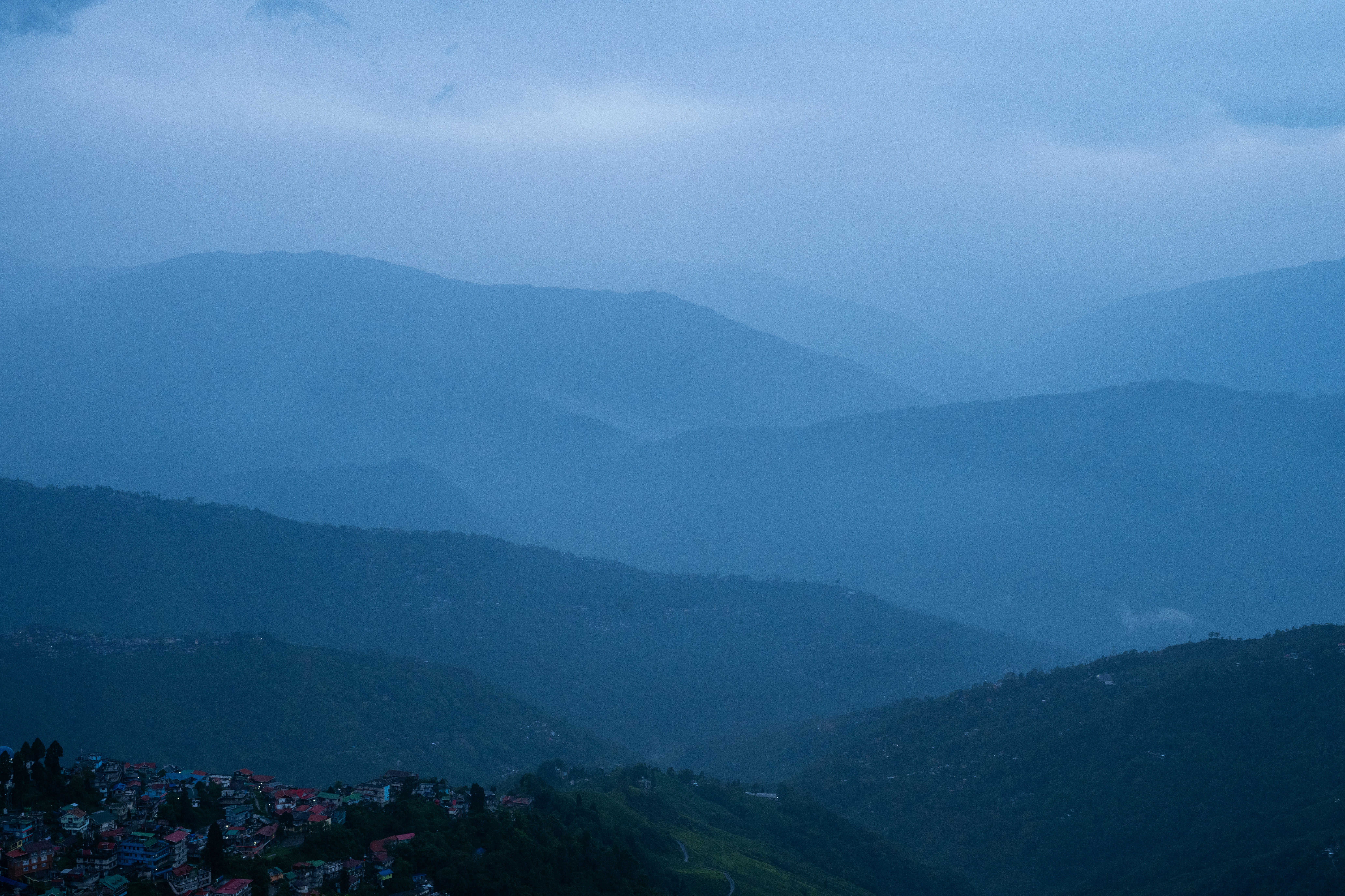 Misty blue mountains with a village below