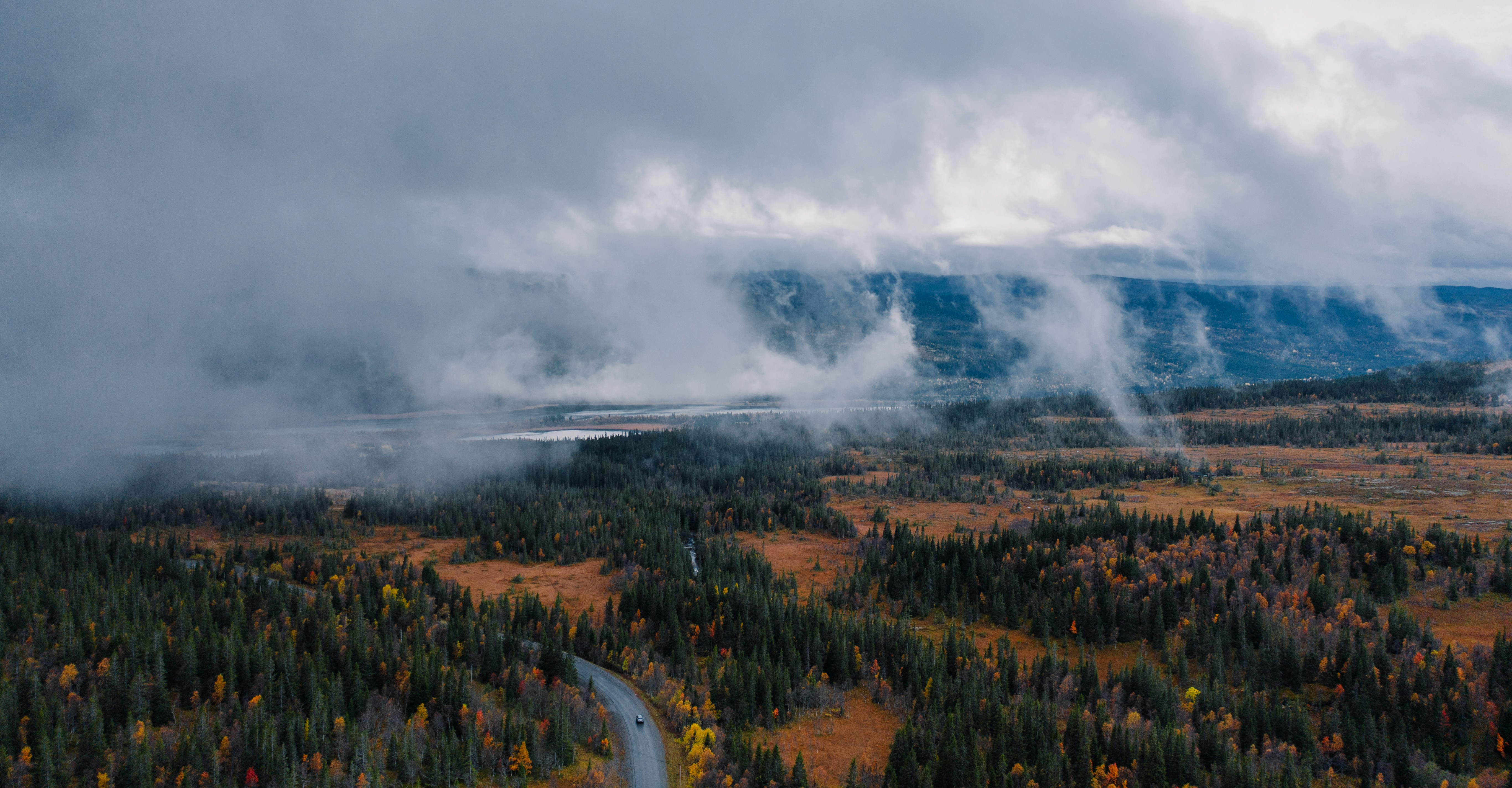 Misty clouds over a forest and lake landscape