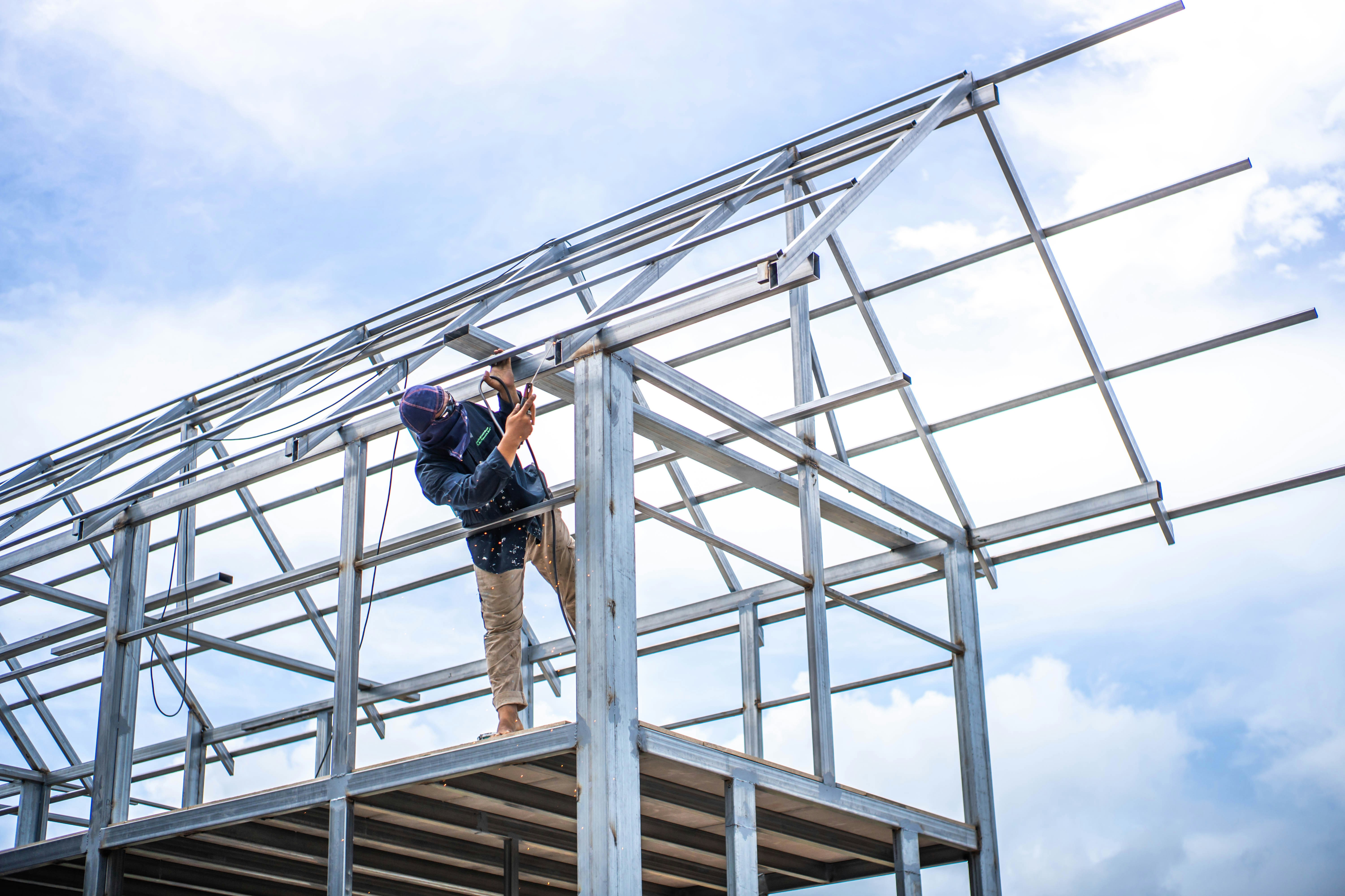 Contractor aligning the first metal panel with a 1-inch eave overhang
