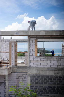 Construction workers building a structure near the ocean.