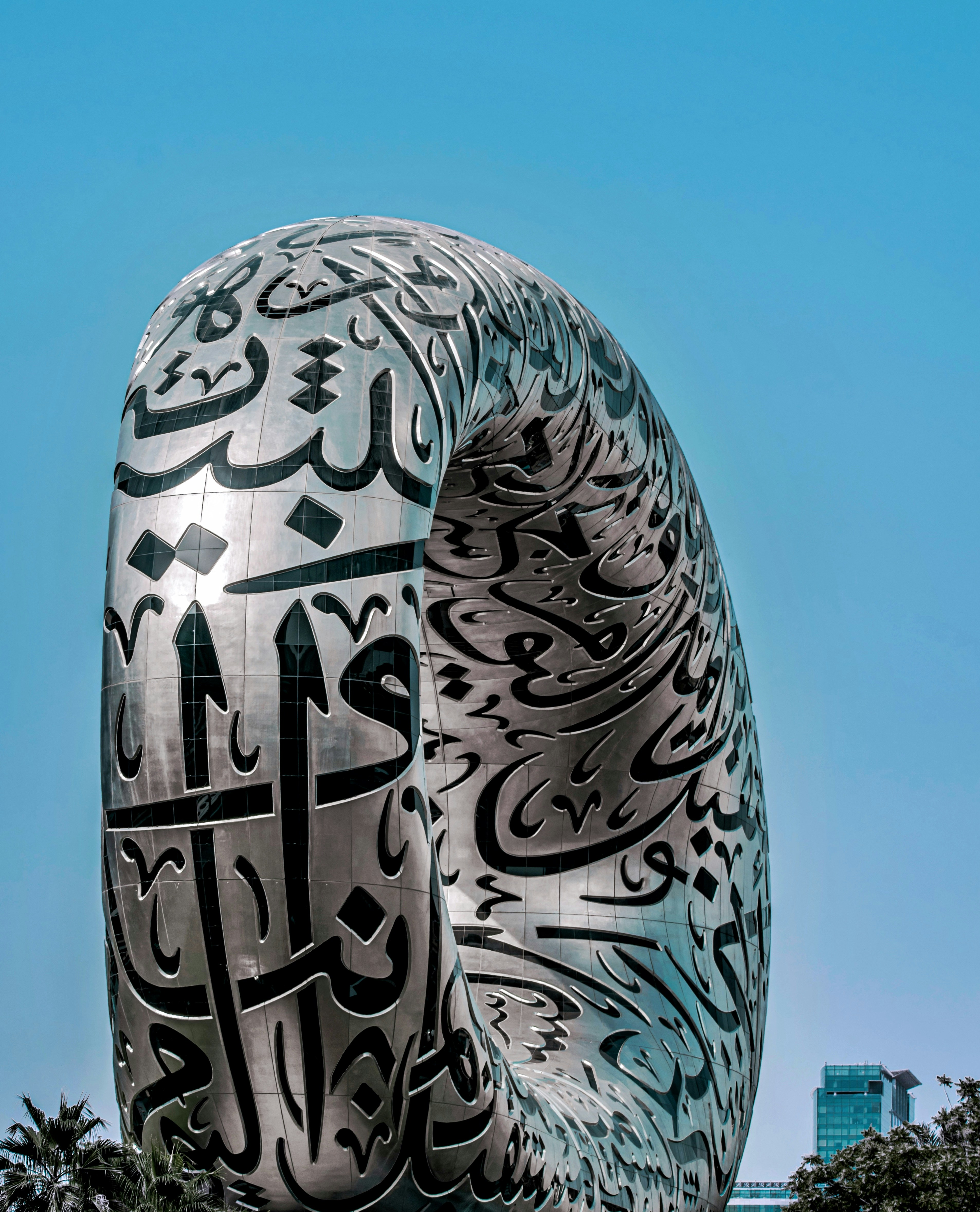 Bangunan modern dengan kaligrafi Arab di bawah langit biru
