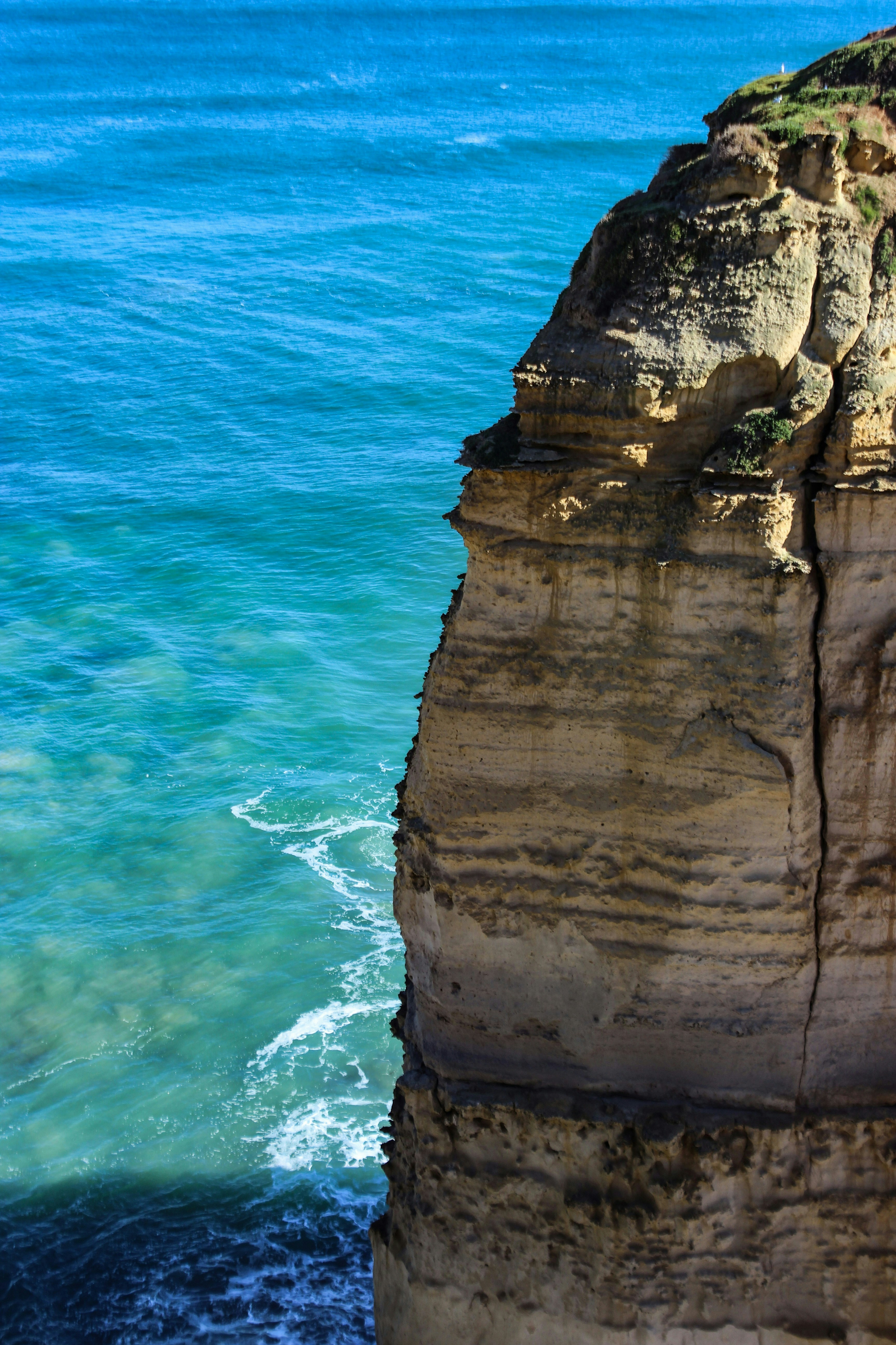 Rugged coastal cliffs meet turquoise ocean waves