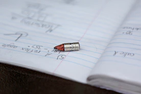 A single bullet rests on an open notebook page.