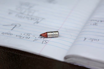 A single bullet rests on an open notebook page.