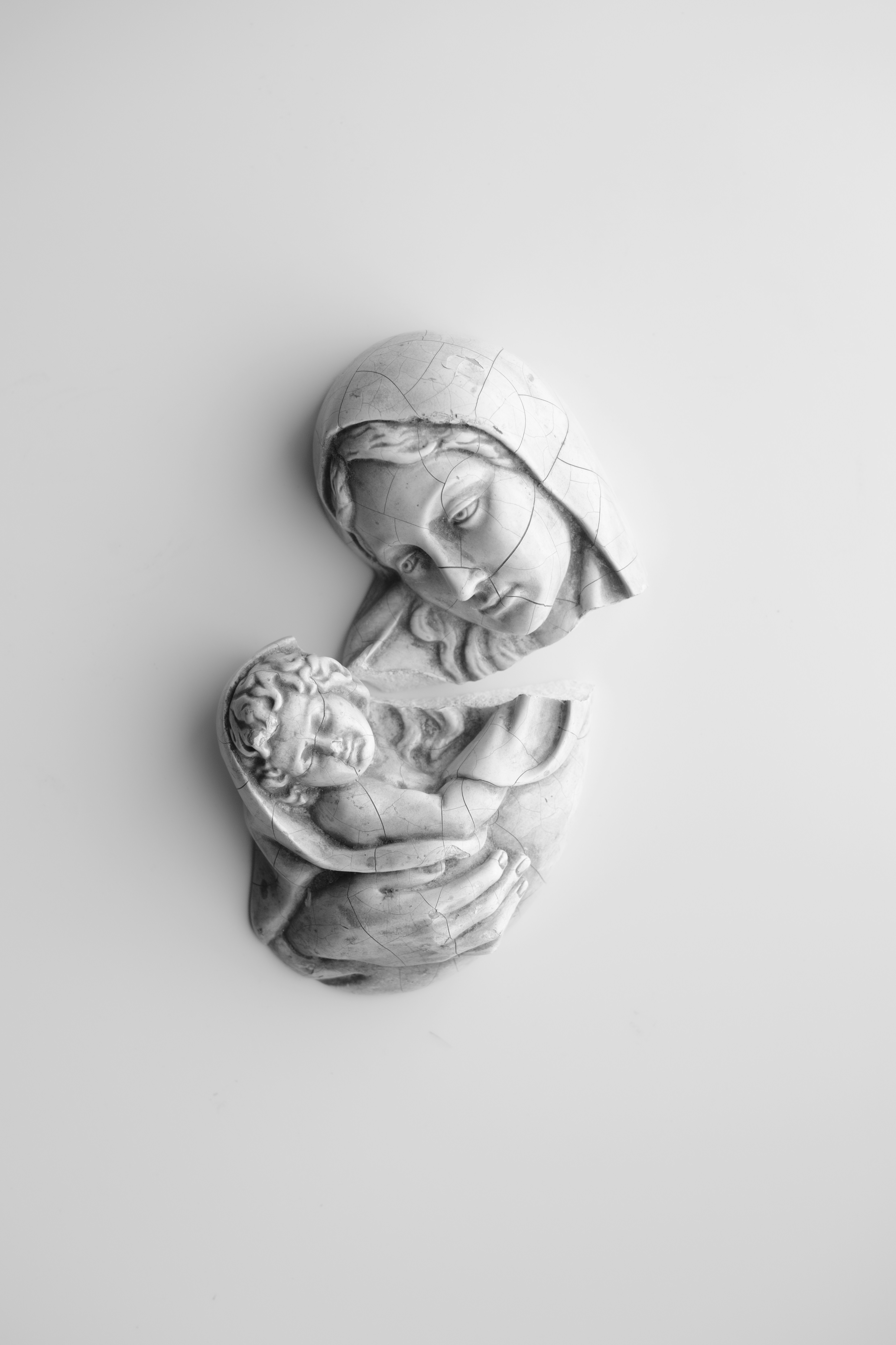 Una scultura di Maria che tiene il bambino Gesù.