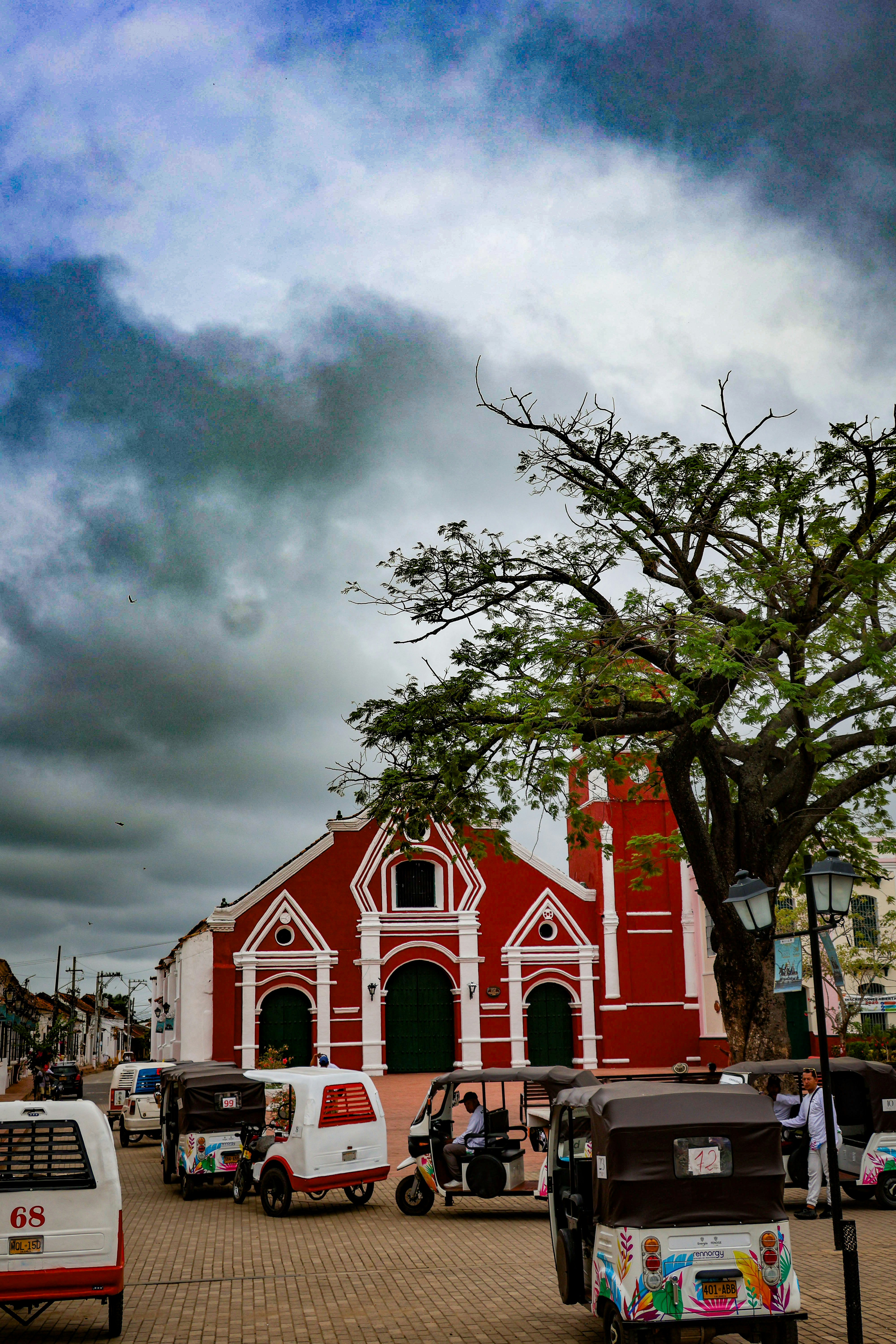 Gereja merah dengan tuk-tuk di alun-alun kota