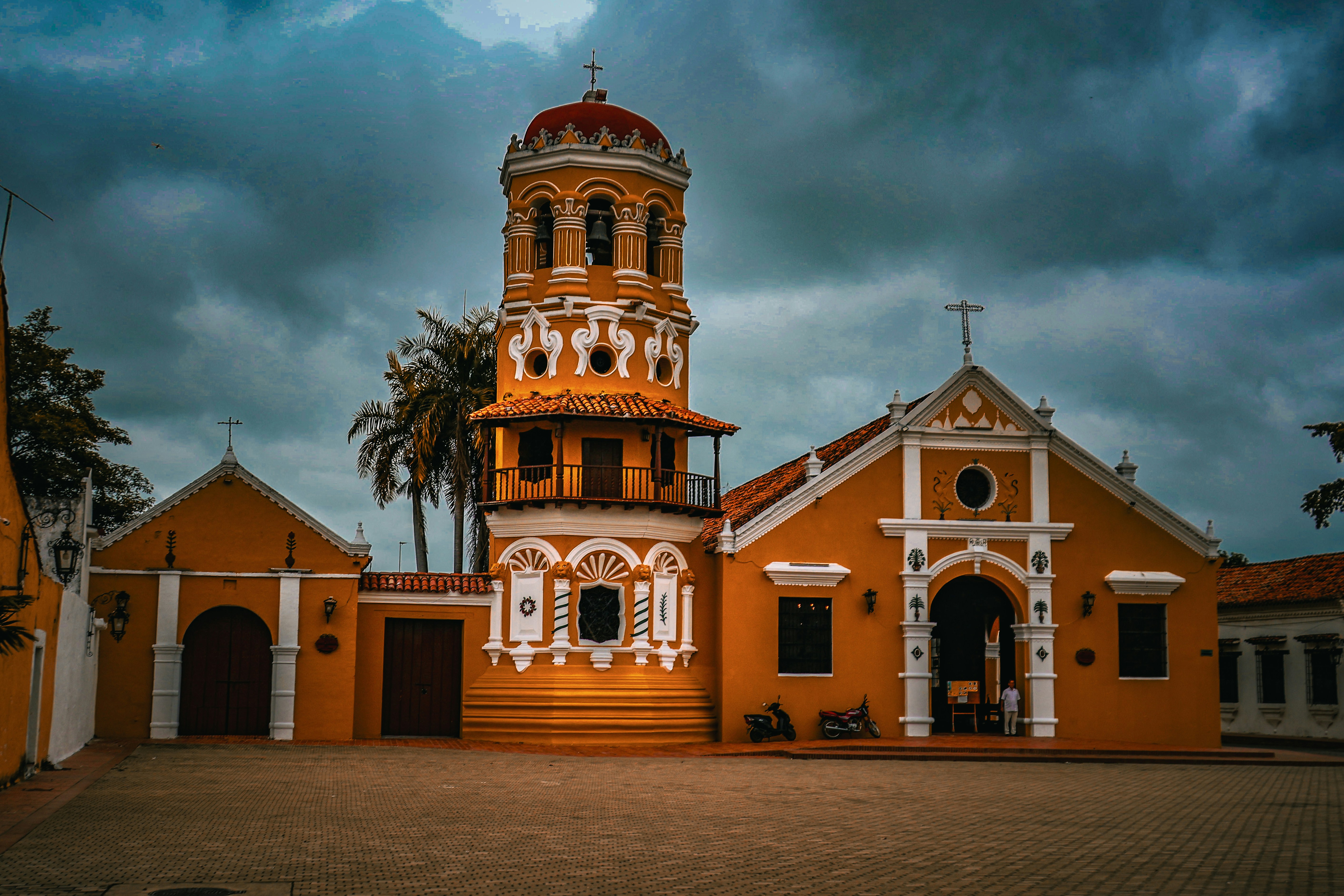 Sebuah gereja kuning cerah dengan menara lonceng yang tinggi.