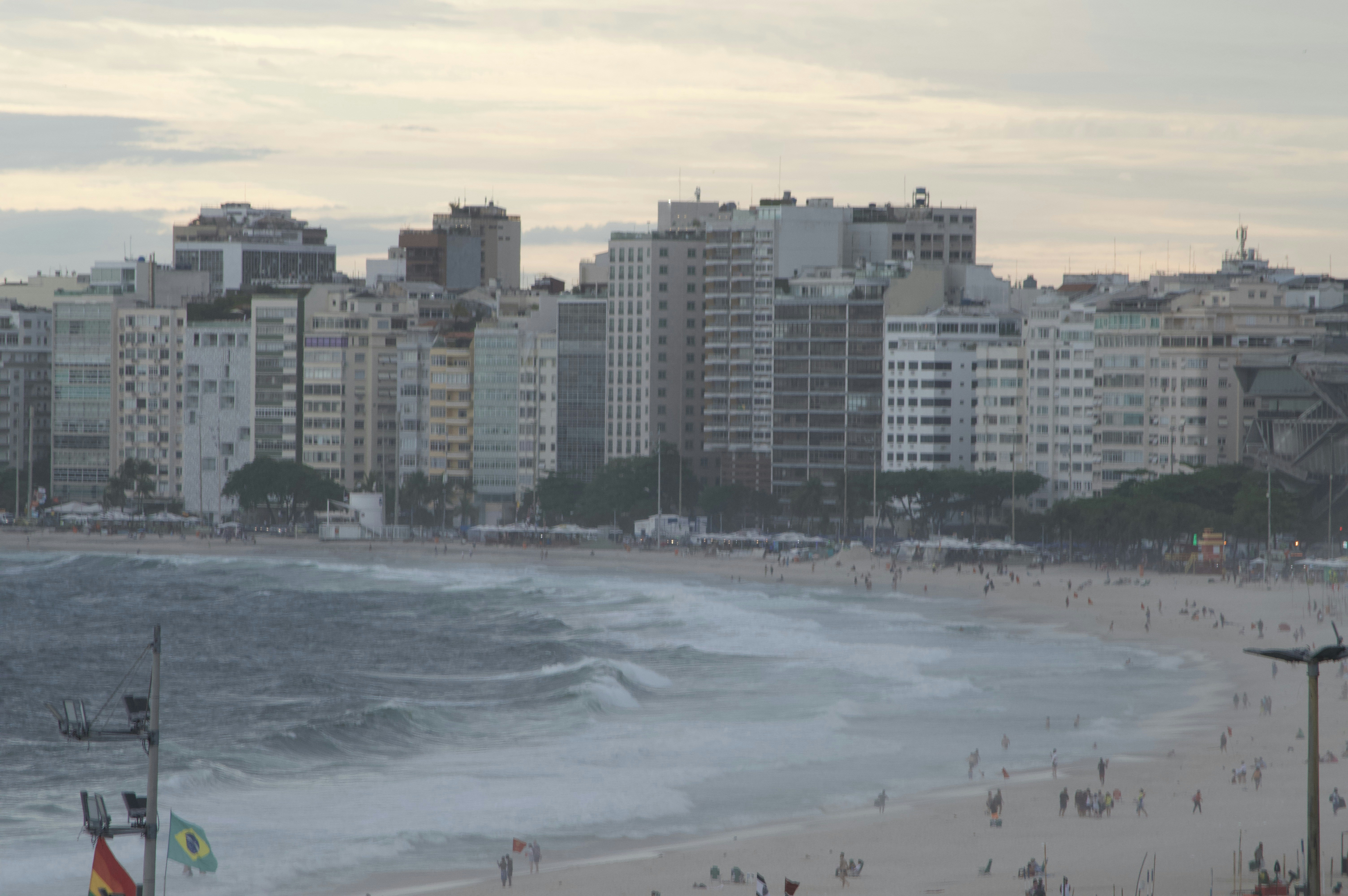 City skyline overlooking a crowded beach and ocean waves