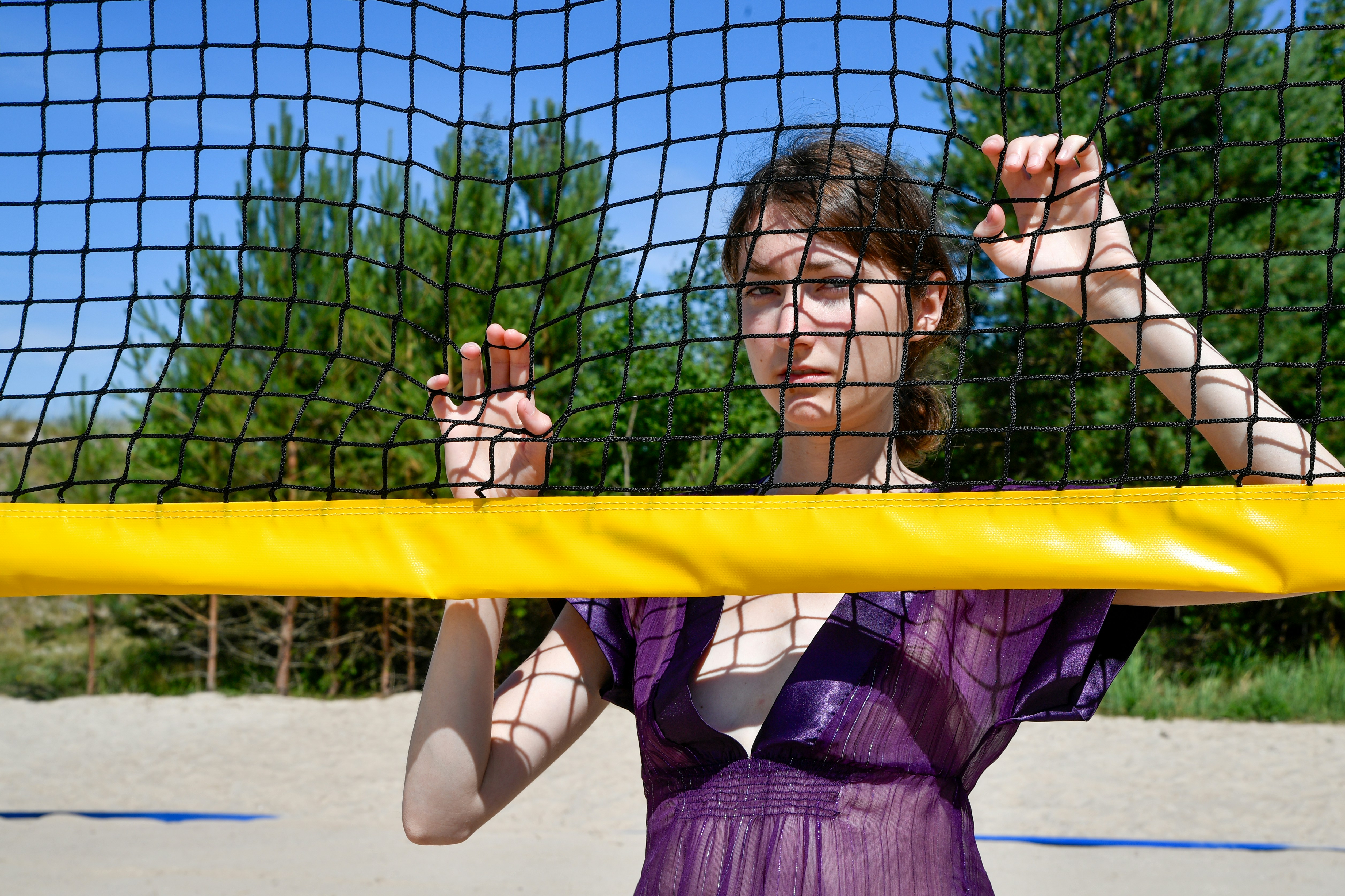 Young woman behind a volleyball net