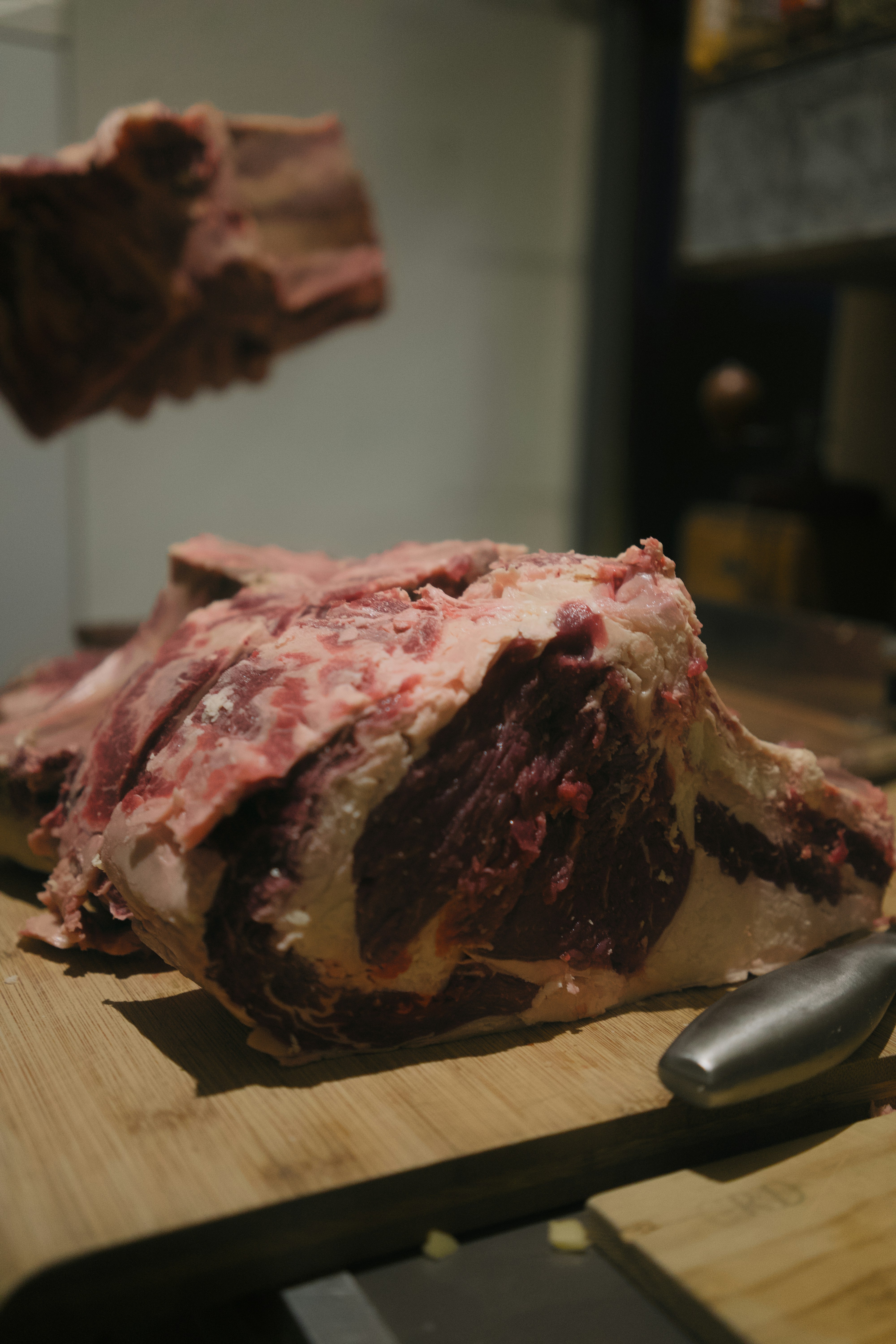 Costillas de ternera crudas sobre una tabla de cortar de madera.