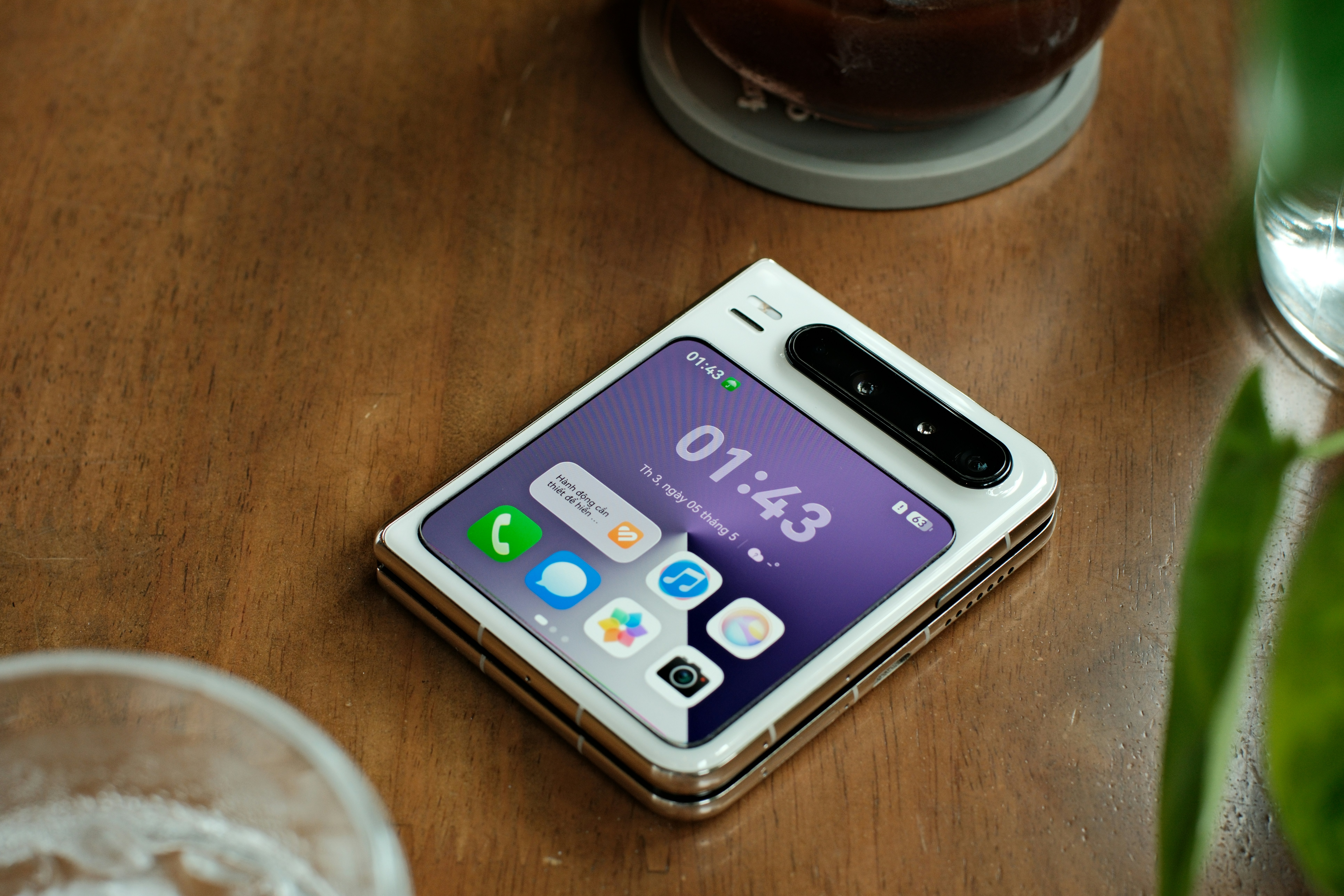 A white foldable smartphone displaying the time on its screen.